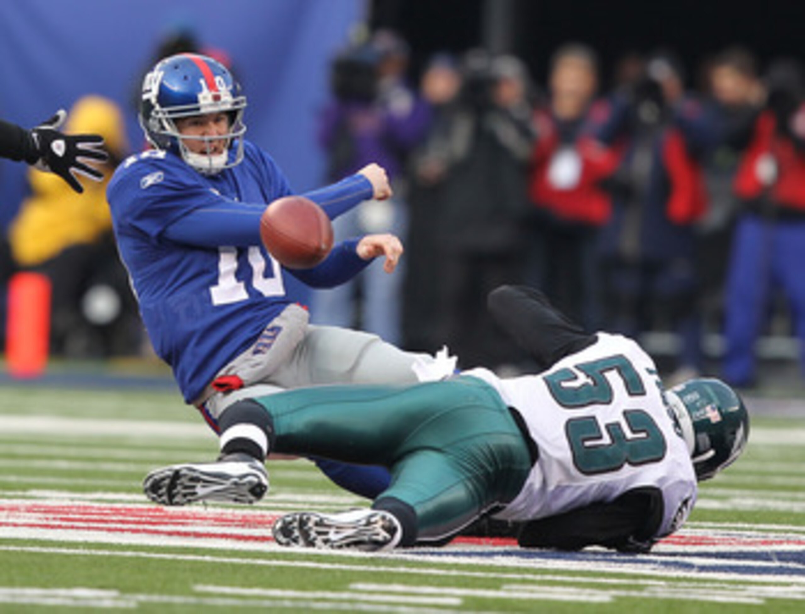 EAST RUTHERFORD, NJ - DECEMBER 19:  Eli Manning #10 of the New York Giants is sacked by Moise Fokou #53 of the Philadelphia Eagles during their game on December 19, 2010 at The New Meadowlands Stadium in East Rutherford, New Jersey.  (Photo by Al Bello/Ge