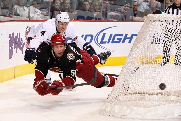 GLENDALE, AZ - JANUARY 25:  Ed Jovanovski #55 of the Phoenix Coyotes draws a triping penalty from Taylor Hall #4 of the Edmonton Oilers as he clears the puck during the first period of the NHL game at Jobing.com Arena on January 25, 2011 in Glendale, Ariz