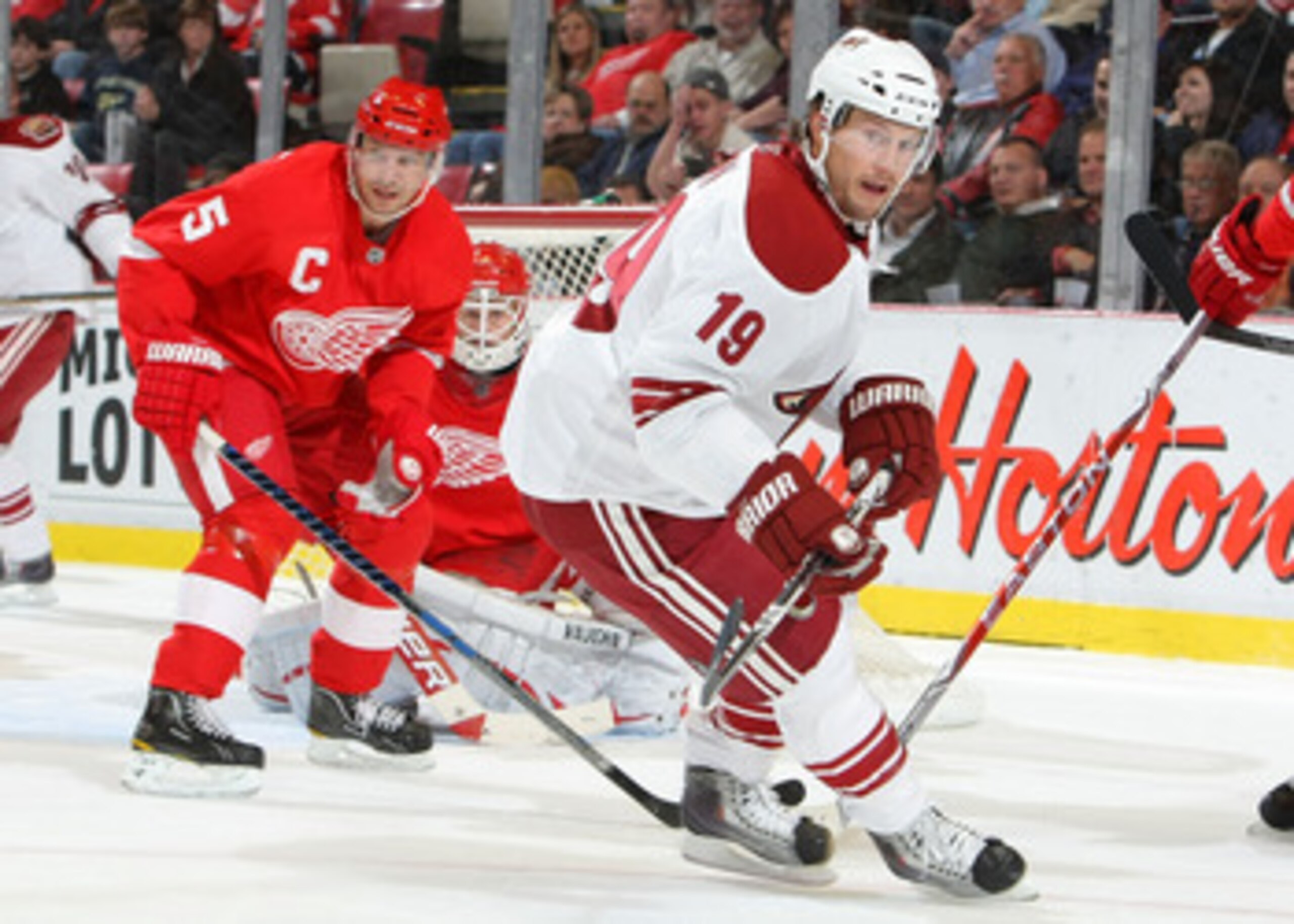 DETROIT - OCTOBER 28:  Nicklas Lidstrom #5 of the Detroit Red Wings keeps an eye on the play as does teammate goalie Chris Osgood #30 and Shane Doan #19 of the Phoenix Coyotes during their NHL game at Joe Louis Arena on October 28, 2010 in Detroit, Michig