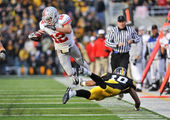 IOWA CITY, IA - NOVEMBER 20: Defenisve back Micah Hyde #18 of the University of Iowa Hawkeyes trips up wide receiver Dane Sanzenbacher #12 of the Ohio State Buckeyes as he drove the ball down field during the first half of play at Kinnick Stadium on Novem
