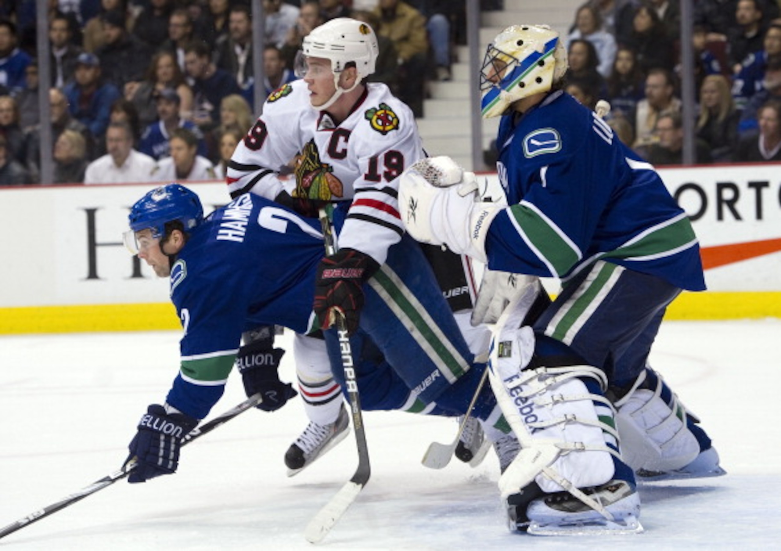 VANCOUVER, CANADA - FEBRUARY 4: Jonathan Toews #19 of the Chicago Blackhawks battles with Dan Hamhuis #2 of the Vancouver Canucks for position in front of goalie Roberto Luongo #1 during the first period in NHL action on February 04, 2011 at Rogers Arena
