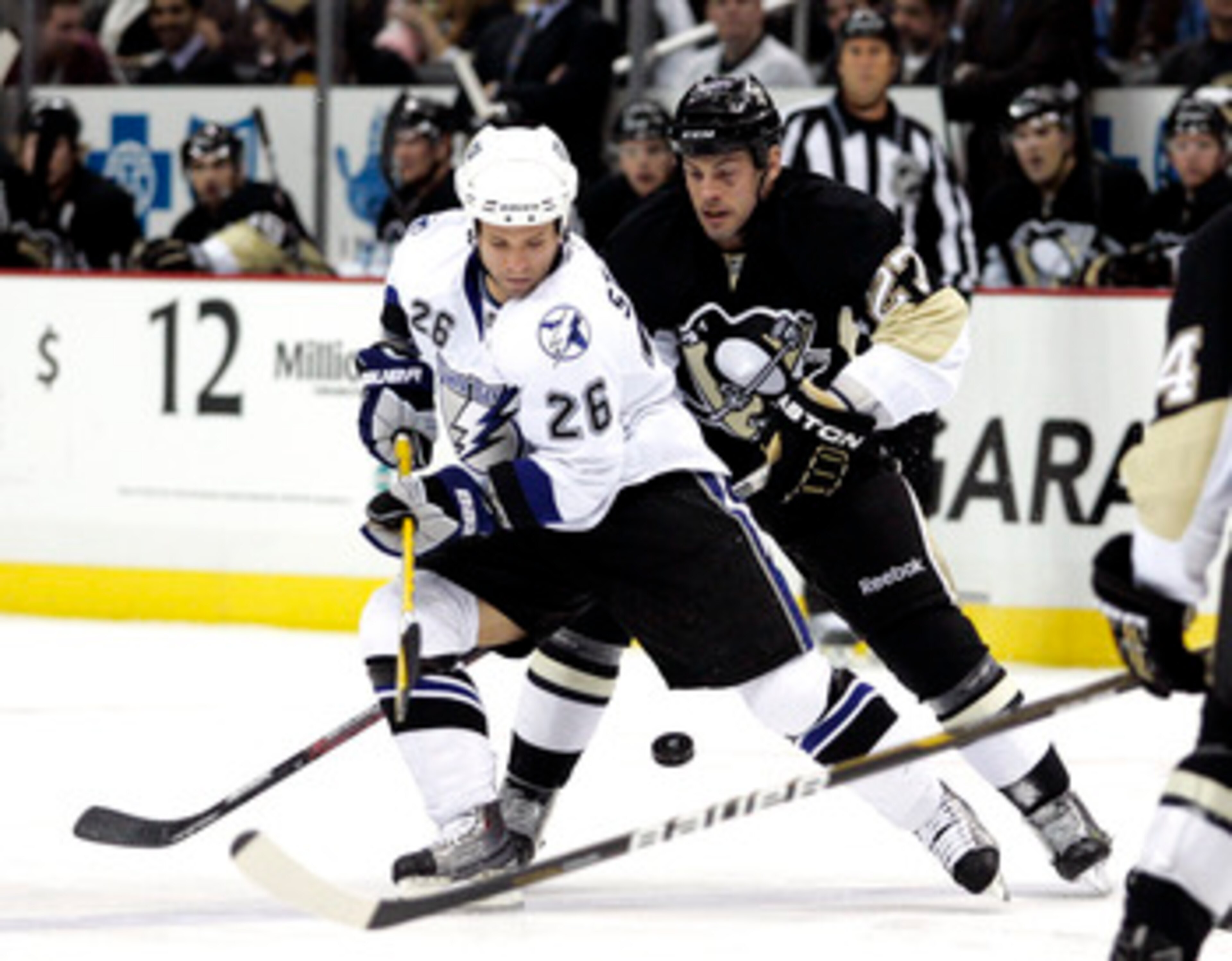 PITTSBURGH, PA - JANUARY 05: Martin St. Louis #26 of the Tampa Bay Lightning handles the puck against Craig Adams #27 of the Pittsburgh Penguins on January 5, 2011 at Consol Energy Center in Pittsburgh, Pennsylvania. (Photo by Justin K. Aller/Getty Imag PITTSBURGH, PA - JANUARY 05: Martin St. Louis #26 of the Tampa Bay Lightning handles the puck against Craig Adams #27 of the Pittsburgh Penguins on January 5, 2011 at Consol Energy Center in Pittsburgh, Pennsylvania. (Photo by Justin K. Aller/Getty Imag