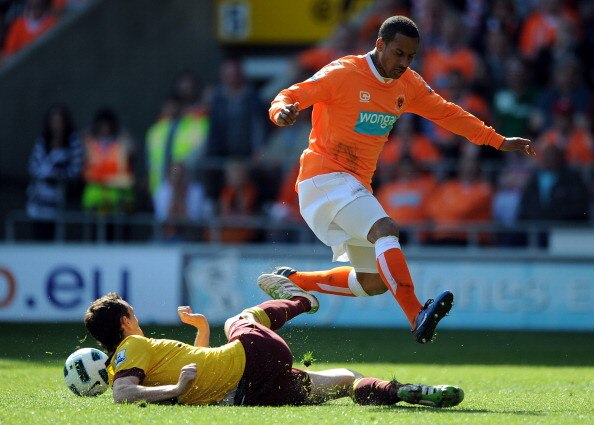 BLACKPOOL, ENGLAND - APRIL 10:  Sebastien Squillaci of Arsenal challenges DJ Campbell of Blackpool during the Barclays Premier League match between Blackpool and Arsenal at Bloomfield Road on April 10, 2011 in Blackpool, England.  (Photo by Chris Brunskil