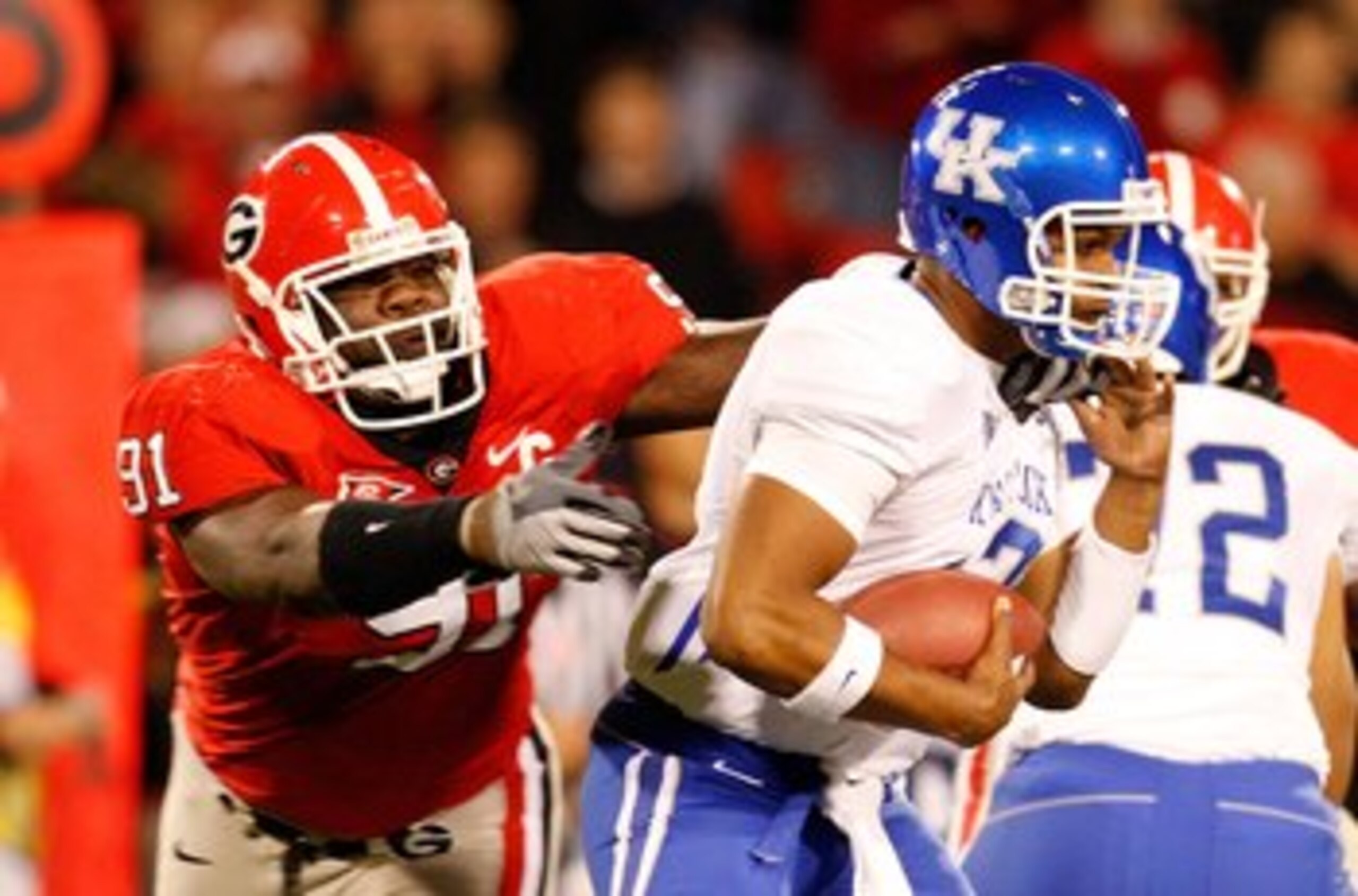 ATHENS, GA - NOVEMBER 21:  Quarterback Morgan Newton #12 of the Kentucky Wildcats escapes a tackle by Kade Weston #91 of the Georgia Bulldogs at Sanford Stadium on November 21, 2009 in Athens, Georgia.  (Photo by Kevin C. Cox/Getty Images)