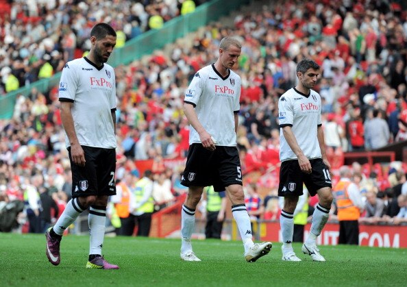 MANCHESTER, ENGLAND - APRIL 09: Brede Hangeland (C) of Fulham walks off dejected with Clint Dempsey (L) and Aaron Hughes after the Barclays Premier League match between Manchester United and Fulham at Old Trafford on April 9, 2011 in Manchester, England.