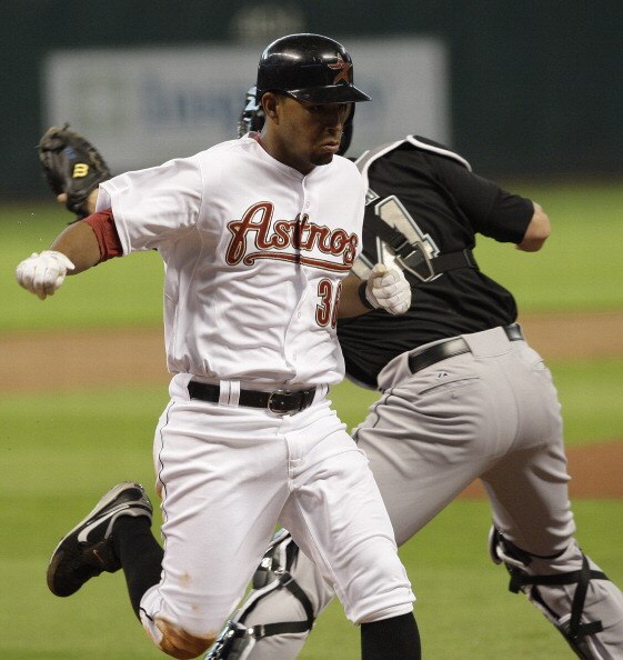 HOUSTON,TX- APRIL 9 : Angel Sanchez #36 of the Houston Astros scores on Hunter Pence's #9 RBI in the bottom of the first inning while catcher John Buck #14 of the Florida Marlins waits for the ball in a MLB  baseball game on April 9, 2011 at Minute Maid P