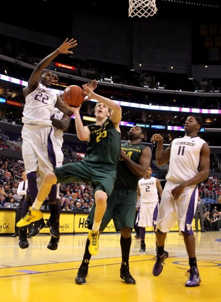 LOS ANGELES, CA - MARCH 11:  E.J. Singler #25 of the Oregon Ducks goes up for a shot against Justin Holiday #22 of the Washington Huskies in the second half in the semifinals of the 2011 Pacific Life Pac-10 Men's Basketball Tournament at Staples Center on