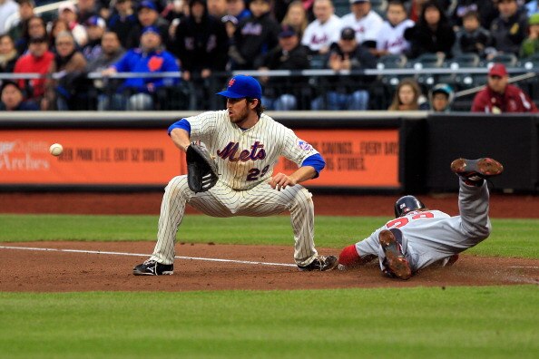 NEW YORK, NY - APRIL 08:  Jayson Werth #28 of the Washington Nationals slides head first safely into first base on an infield single in the top of the fifth inning against Ike Davis #29 of the New York Mets during the Mets' Home Opener at Citi Field on Ap
