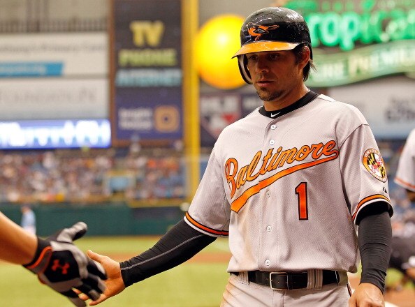 ST. PETERSBURG, FL - APRIL 03:  Infielder Brian Roberts #1 of the Baltimore Orioles is congratulated after scoring a first inning run against the Tampa Bay Rays during the game at Tropicana Field on April 3, 2011 in St. Petersburg, Florida.  (Photo by J.