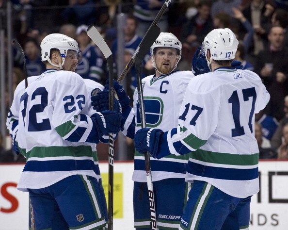 VANCOUVER, CANADA - FEBRUARY 22: Henrik Sedin #33 celebrates with Daniel Sedin #22 and Ryan Kesler #17 of the Vancouver Canucks after scoring a power play goal against the Montreal Canadiens during the second period in NHL action on February 22, 2011 at R