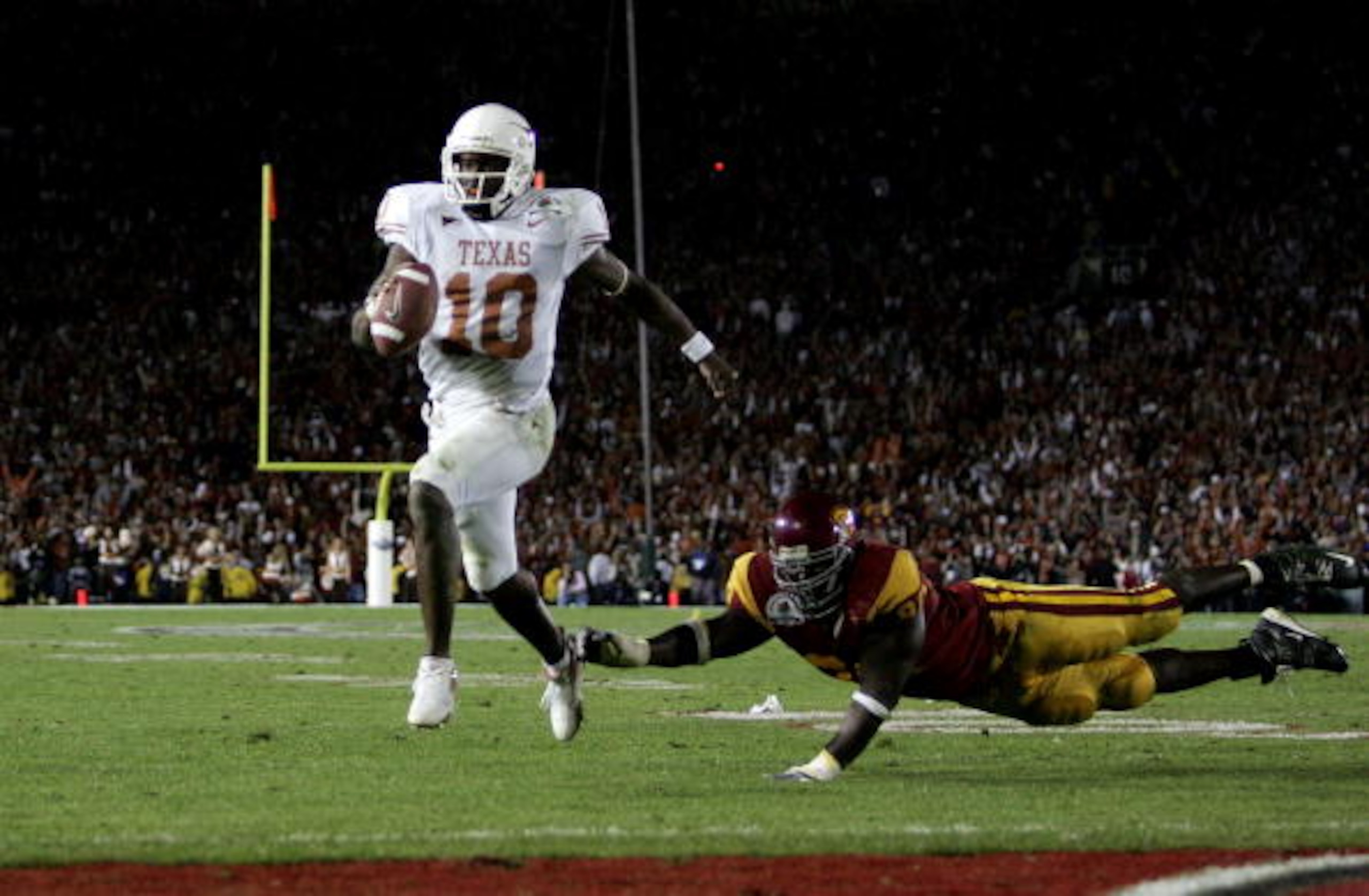 PASADENA, CA - JANUARY 04:  Vince Young #10 of the Texas Longhorns runs past Frostee Rucker #90 of the USC Trojans to score a touchdown and put the Longhorns up by one in the final moments of the BCS National Championship Rose Bowl Game at the Rose Bowl o