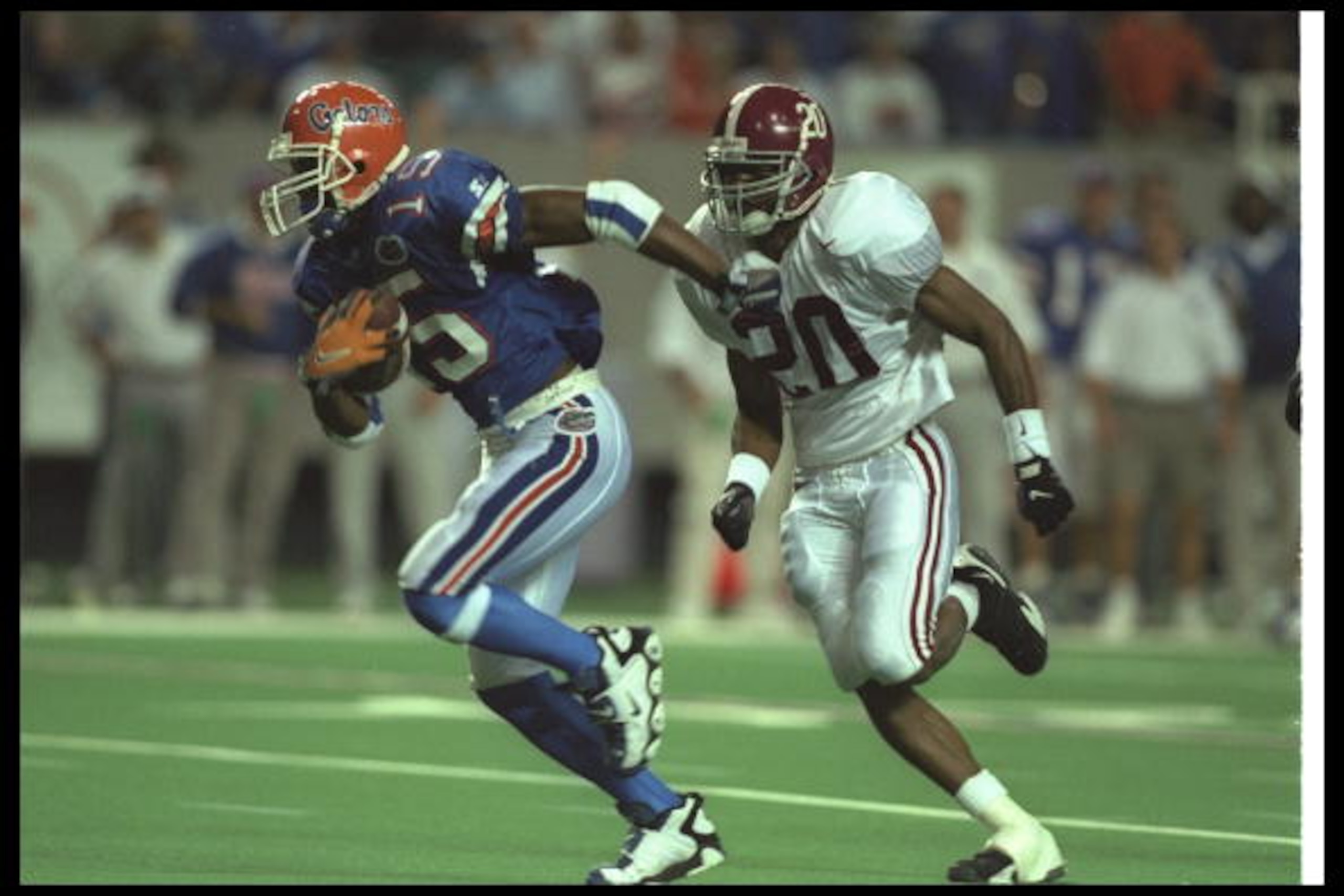 7 Dec 1996:  Wide receiver Reidel Anthony of the Florida Gators (left) runs with the ball as Alabama Crimson Tide defensive back Kelvin Sigler chases him during the SEC Championship game at the Georgia Dome in Atlanta, Georgia.  Florida won the game, 45-3