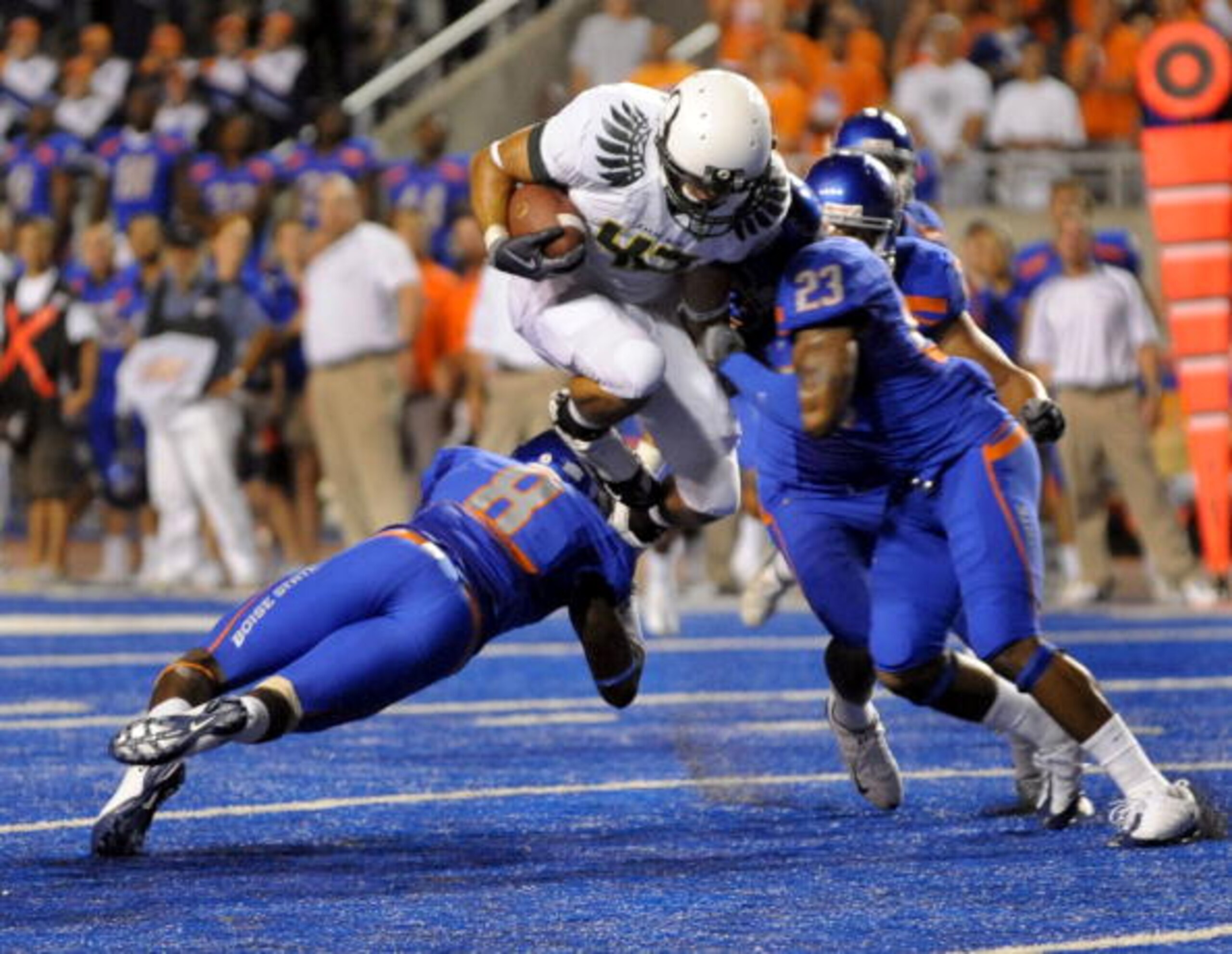 BOISE, ID - SEPTEMBER 3: Tight end David Paulson #42 of the Oregon Ducks leaps over George Iloka #8 of the Boise State Broncos as he is hit by safety Jeron Johnson #23 of the Boise State Broncos in the third quarter of the game on September 3, 2009 at Bro BOISE, ID - SEPTEMBER 3: Tight end David Paulson #42 of the Oregon Ducks leaps over George Iloka #8 of the Boise State Broncos as he is hit by safety Jeron Johnson #23 of the Boise State Broncos in the third quarter of the game on September 3, 2009 at Bro