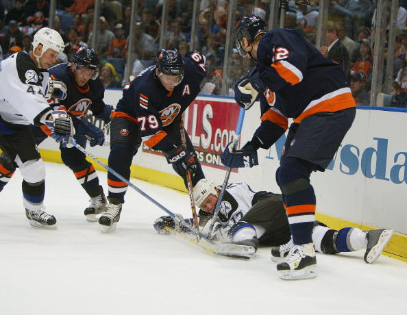UNIONDALE, NY - APRIL 14:  Alexei Yashin #79 and Oleg Kvasha #12 of the New York Islanders dig for the puck as Ruslan Fedotenko #17 of the Tampa Bay Lightning scrambles to cover the puck during game four of the Eastern Conference Quarterfinals of the 2004