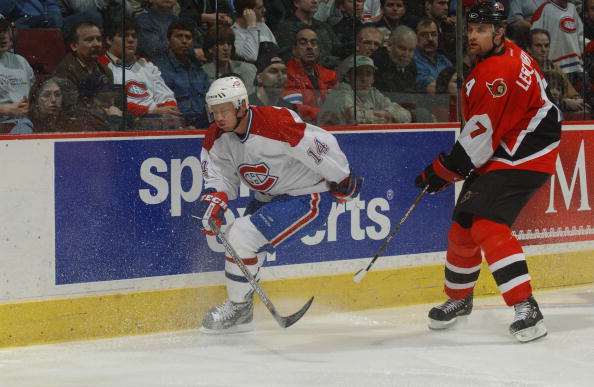 MONTREAL, CANADA - APRIL 9:  Right wing Oleg Petrov #14 of the Montreal Canadiens skates behind the net with defenseman Curtis Leschyshyn #7 of the Ottawa Senators during the game at Molson Centre in Montreal, Quebec, Canada on April 9, 2002.  The Canadie
