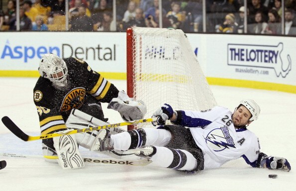 BOSTON, MA - MARCH 03:  Tim Thomas #30 of the Boston Bruins stops a shot as Martin St. Louis #26 of the Tampa Bay Lightning runs into him in the second period on March 3, 2011 at the TD Garden in Boston, Massachusetts.  (Photo by Elsa/Getty Images)