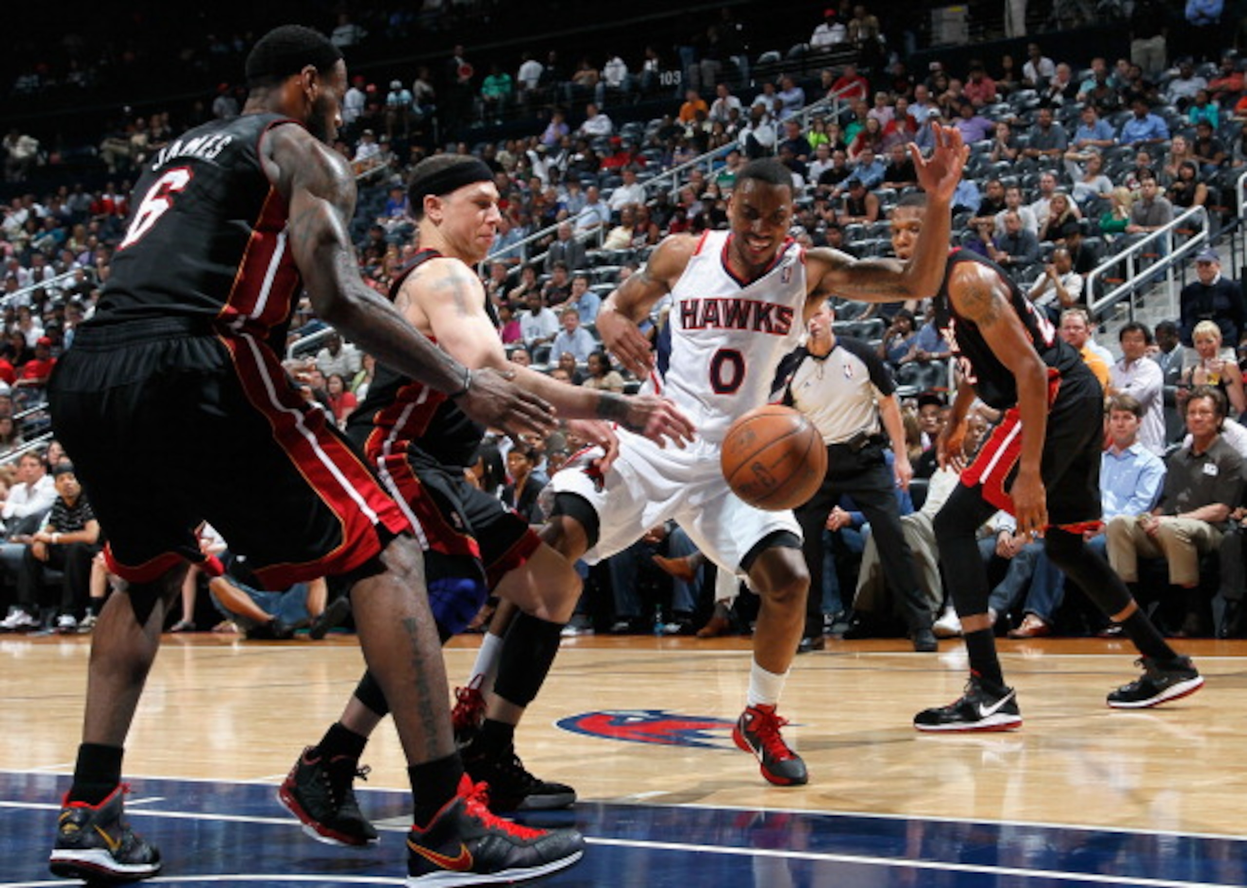 ATLANTA, GA - APRIL 11:  Jeff Teague #0 of the Atlanta Hawks loses the ball as he drives against LeBron James #6 and Mike Bibby #0 of the Miami Heat at Philips Arena on April 11, 2011 in Atlanta, Georgia.  NOTE TO USER: User expressly acknowledges and agr