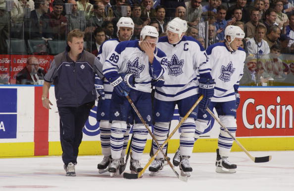 TORONTO - MAY 21:  A trainer helps right wing Alexander Mogilny #89 of the Toronto Maple Leafs off the ice as center Mats Sundin #13 talks to him during game three of the Eastern Conference finals against the Carolina Hurricanes during the Stanley Cup pla
