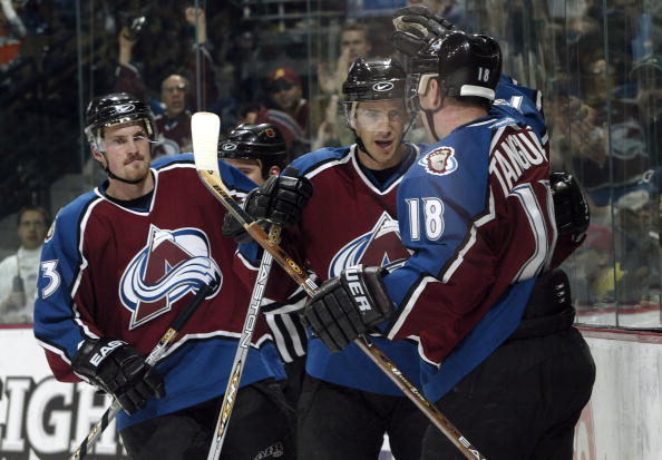 DENVER - NOVEMBER 20:  Joe Sakic #19 and Alex Tanguay #18 of the Colorado Avalanche celebrate after combining for a power play goal against the New York Rangers in the first period November 20, 2003 at the Pepsi Center in Denver, Colorado.  Milan Hejduk #