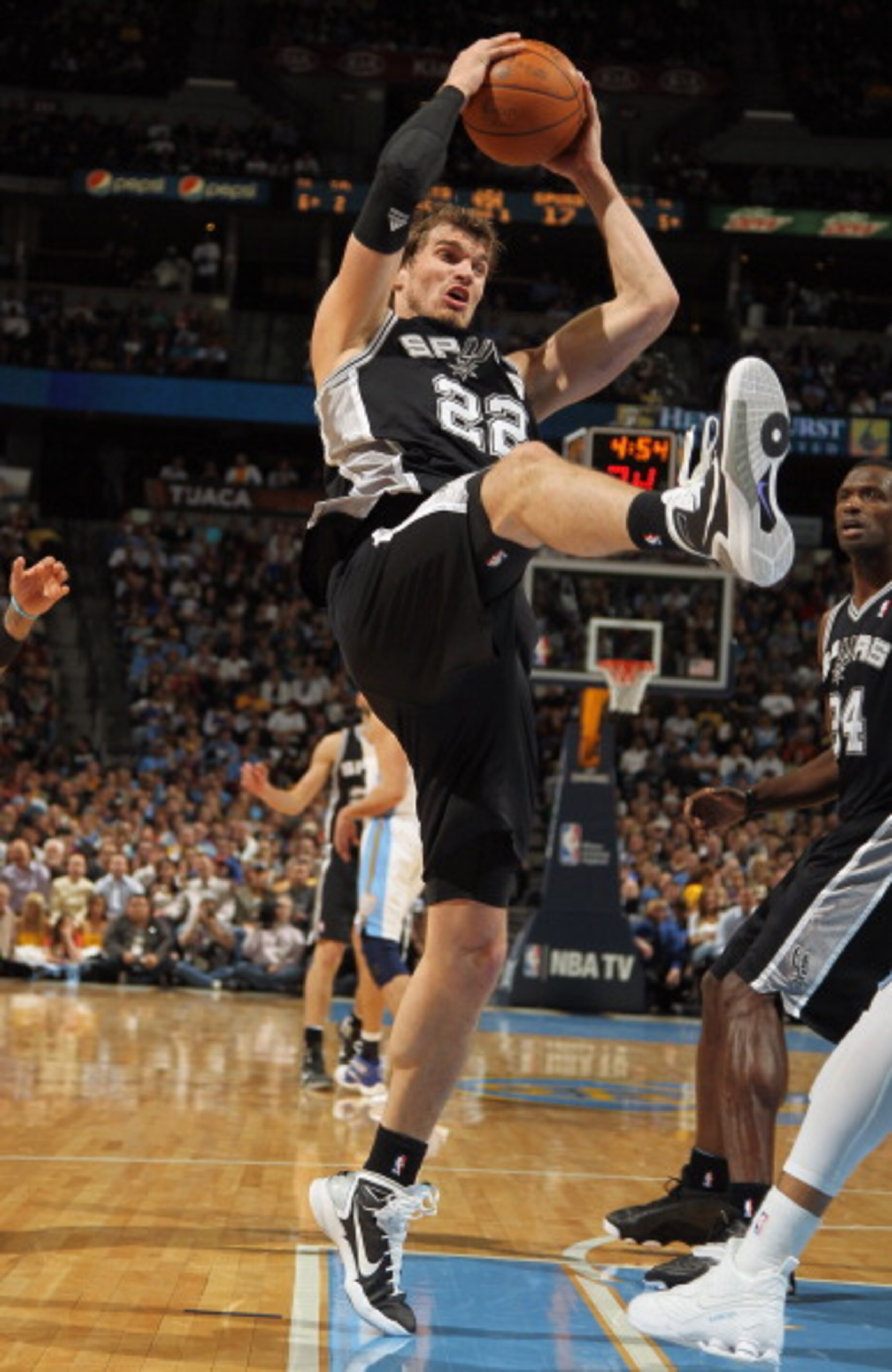 DENVER, CO - MARCH 23:  Tiago Splitter #22 of the San Antonio Spurs grabs a rebound against the Denver Nuggets at the Pepsi Center on March 23, 2011 in Denver, Colorado. The Nuggets defeated the Spurs 115-112. NOTE TO USER: User expressly acknowledges and
