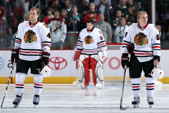 GLENDALE, AZ - MARCH 20:  (L-R) Niklas Hjalmarsson #4, goaltender Corey Crawford #50 and Patrick Kane #88 of the Chicago Blackhawks stand attended for the National Anthem before the NHL game against the Phoenix Coyotes at Jobing.com Arena on March 20, 201