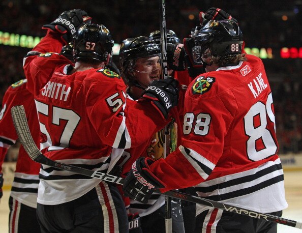 CHICAGO, IL - APRIL 10: Michael Frolik #67 of the Chicago Blackhawks (center) is congratulated by teammates including Ben Smith #57 and Patrick Kane #88 after scoring a goal in the 2nd period against the Detroit Red Wings at the United Center on April 10,