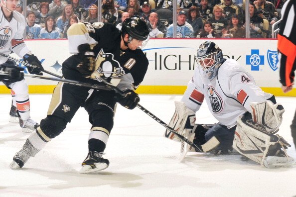 PITTSBURGH, PA - MARCH 13:  Chris Kunitz #14 of the Pittsburgh Penguins slips the puck past goaltender Devan Dubnyk #40 of the Edmonton Oilers for a goal in the first period on March 13, 2011 at CONSOL Energy Center in Pittsburgh, Pennsylvania.  (Photo by