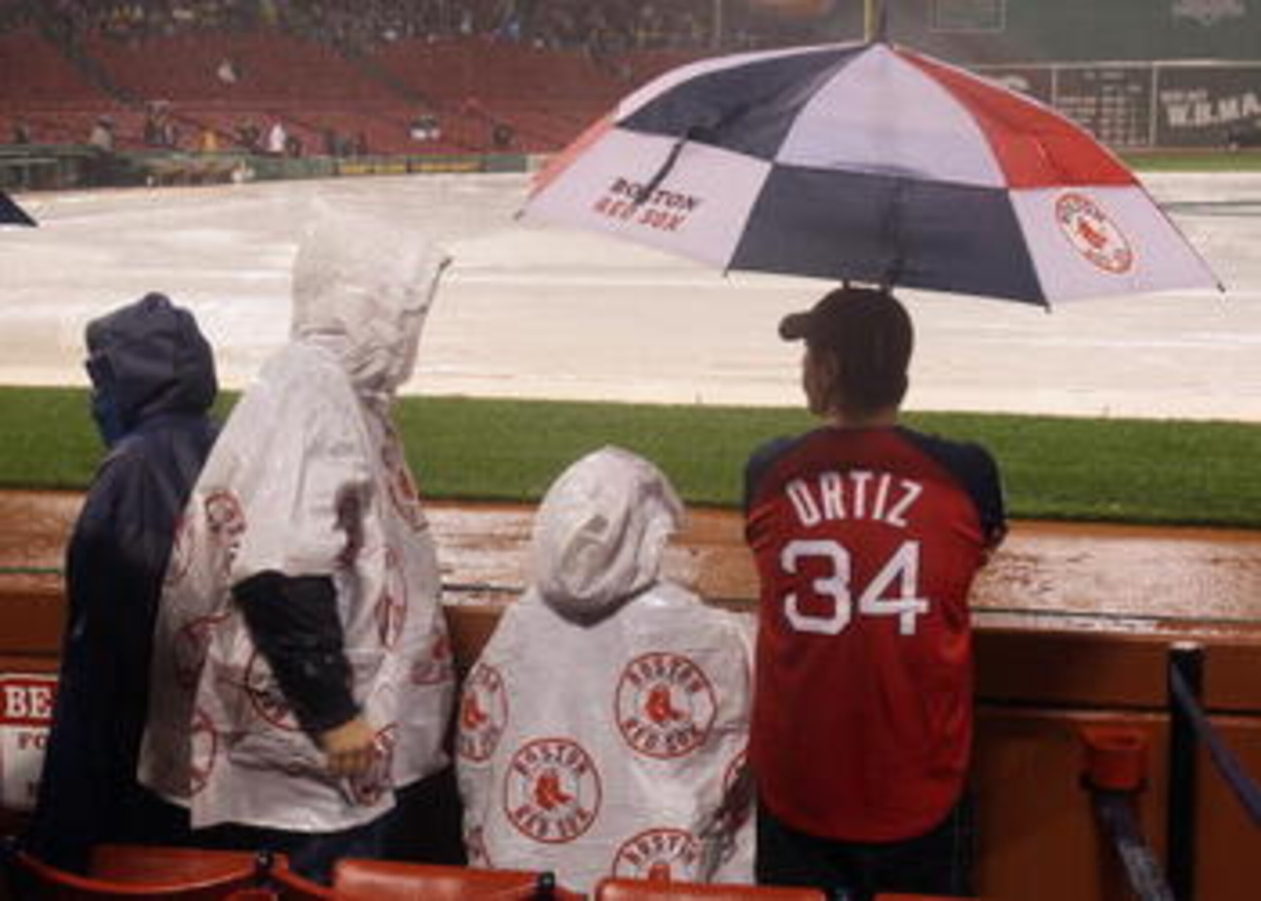 BOSTON - OCTOBER 01:  Fans patiently wait to hear that game between Boston Red Sox and the New York Yankees is postponed until tomorrow due to rain on October 1, 2010 at Fenway Park in Boston, Massachusetts.  (Photo by Elsa/Getty Images)