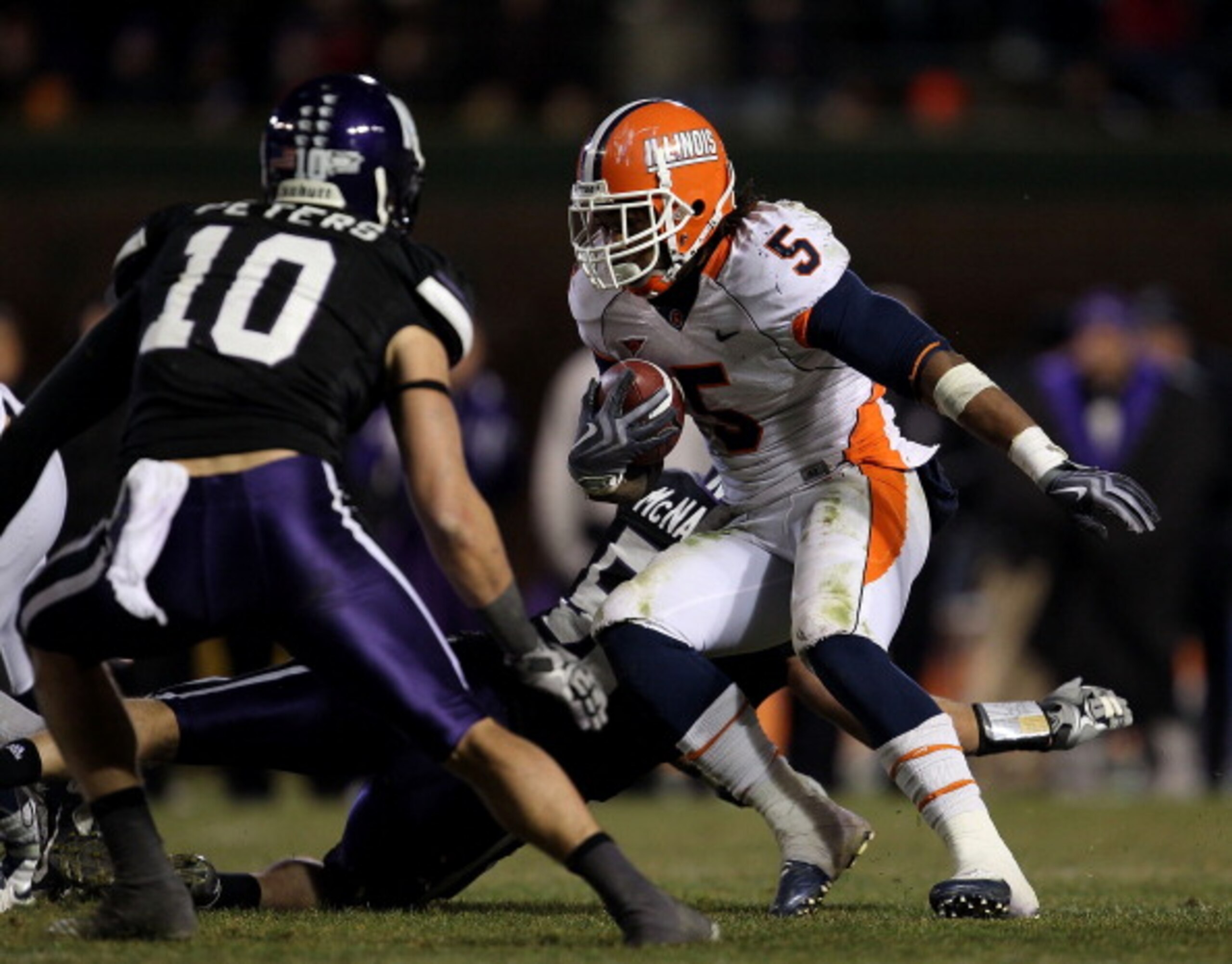 CHICAGO - NOVEMBER 20: Mikel Leshoure #5 of the Illinois Fighting Illini runs as Brian Peters #10 of the Northwestern Wildcats closes in during a game played at Wrigley Field on November 20, 2010 in Chicago, Illinois. Illinois defeated Northwestern 48-27. CHICAGO - NOVEMBER 20: Mikel Leshoure #5 of the Illinois Fighting Illini runs as Brian Peters #10 of the Northwestern Wildcats closes in during a game played at Wrigley Field on November 20, 2010 in Chicago, Illinois. Illinois defeated Northwestern 48-27.