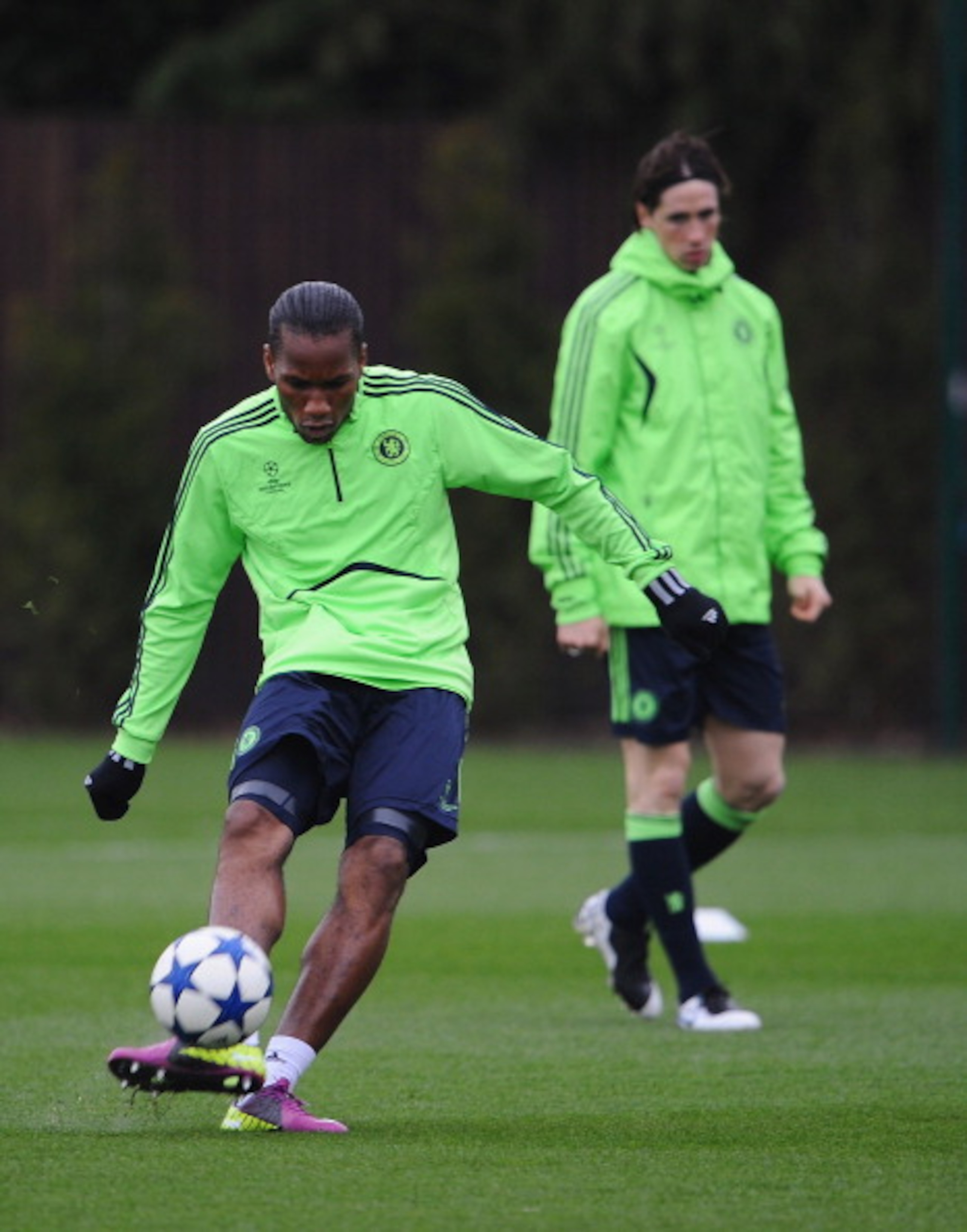 COBHAM, ENGLAND - APRIL 05:  Didier Drogba of Chelsea shoots as team mate Fernando Torres looks on during a Chelsea training session ahead of their UEFA Champions League Quarter-final first leg match against Manchester United, at the Chelsea Football Club