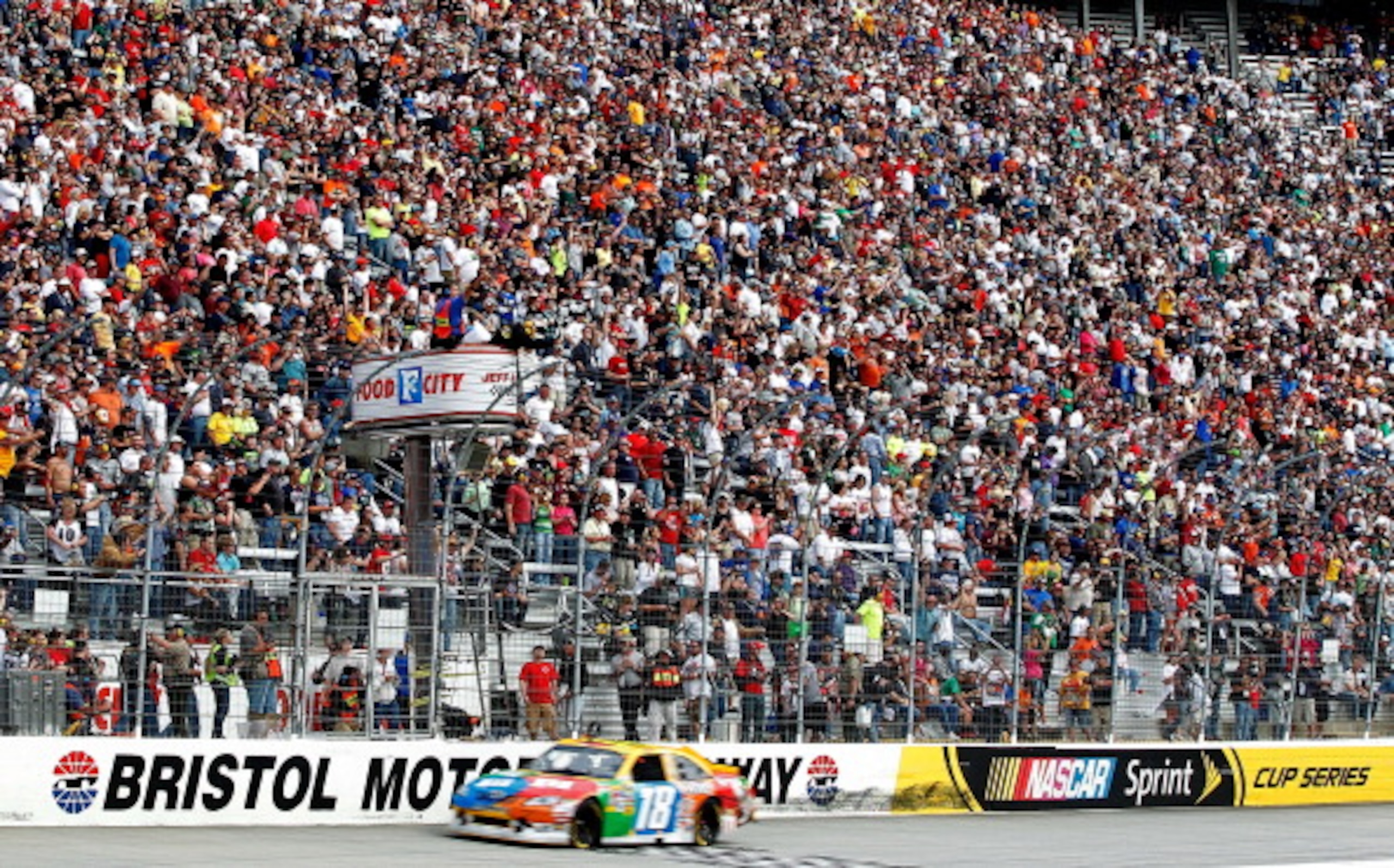BRISTOL, TN - MARCH 20: Kyle Busch, driver of the #18 M&M's Toyota, takes the checkered flag to win the NASCAR Sprint Cup Series Jeff Byrd 500 Presented By Food City at Bristol Motor Speedway on March 20, 2011 in Bristol, Tennessee.  (Photo by Geoff Burke
