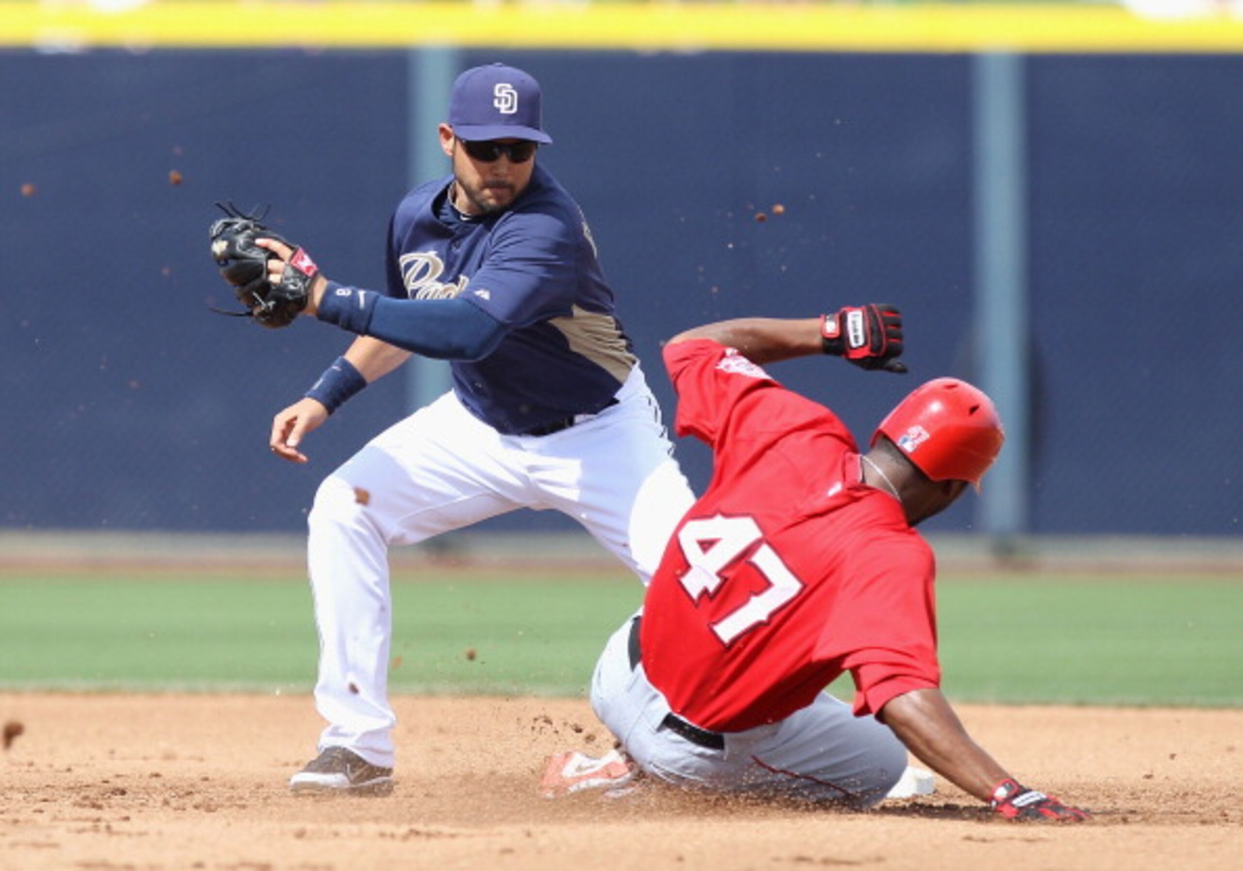 PEORIA, AZ - MARCH 15:  Howard Kendrick #47 of the Los Angeles Angels of Anaheim safely slides into second base past the tag from infielder Jason Bartlett #8 of the San Diego Padres during the spring training game at Peoria Stadium on March 15, 2011 in Pe