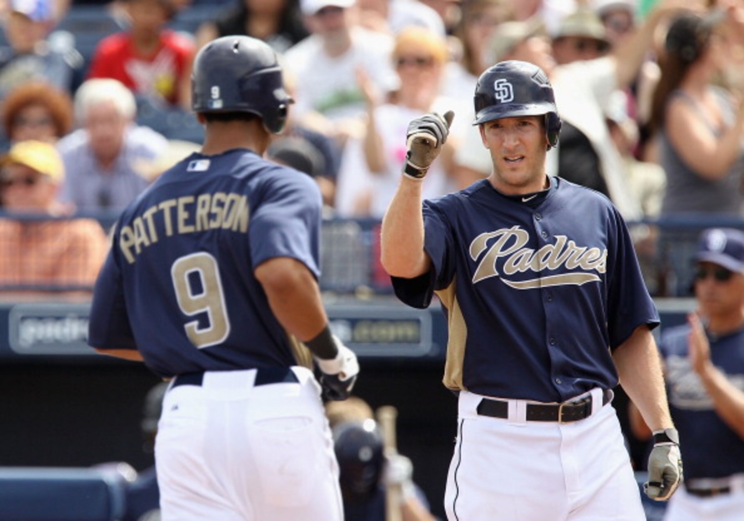 PEORIA, AZ - MARCH 15:  Chris Denorfia #13 of the San Diego Padres high fives teammate Eric Patterson #9 after Patterson hit a 2 run home run against the Los Angeles Angels of Anaheim during the second inning of the spring training game at Peoria Stadium
