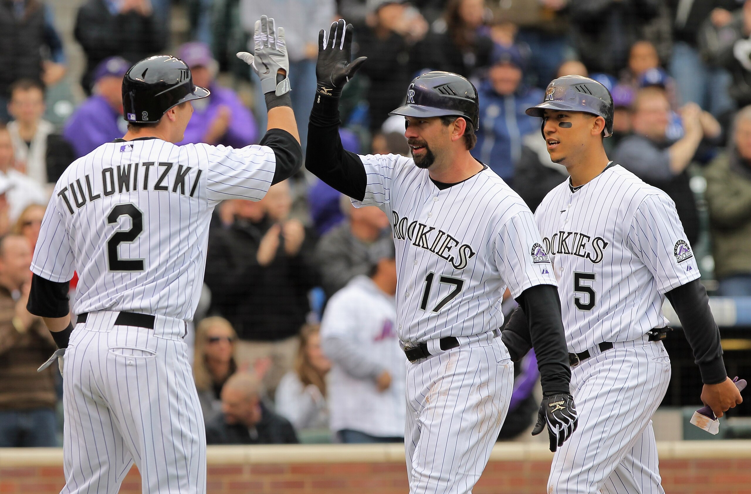 DENVER, CO - APRIL 06:  First baseman Todd Helton #17 of the Colorado Rockies is welcomed home by Troy Tulowitzki #2 of the Rockies and Carlos Gonzalez #5 of the Rockies after they scored on Helton's three run homerun off of starting pitcher Chad Billings