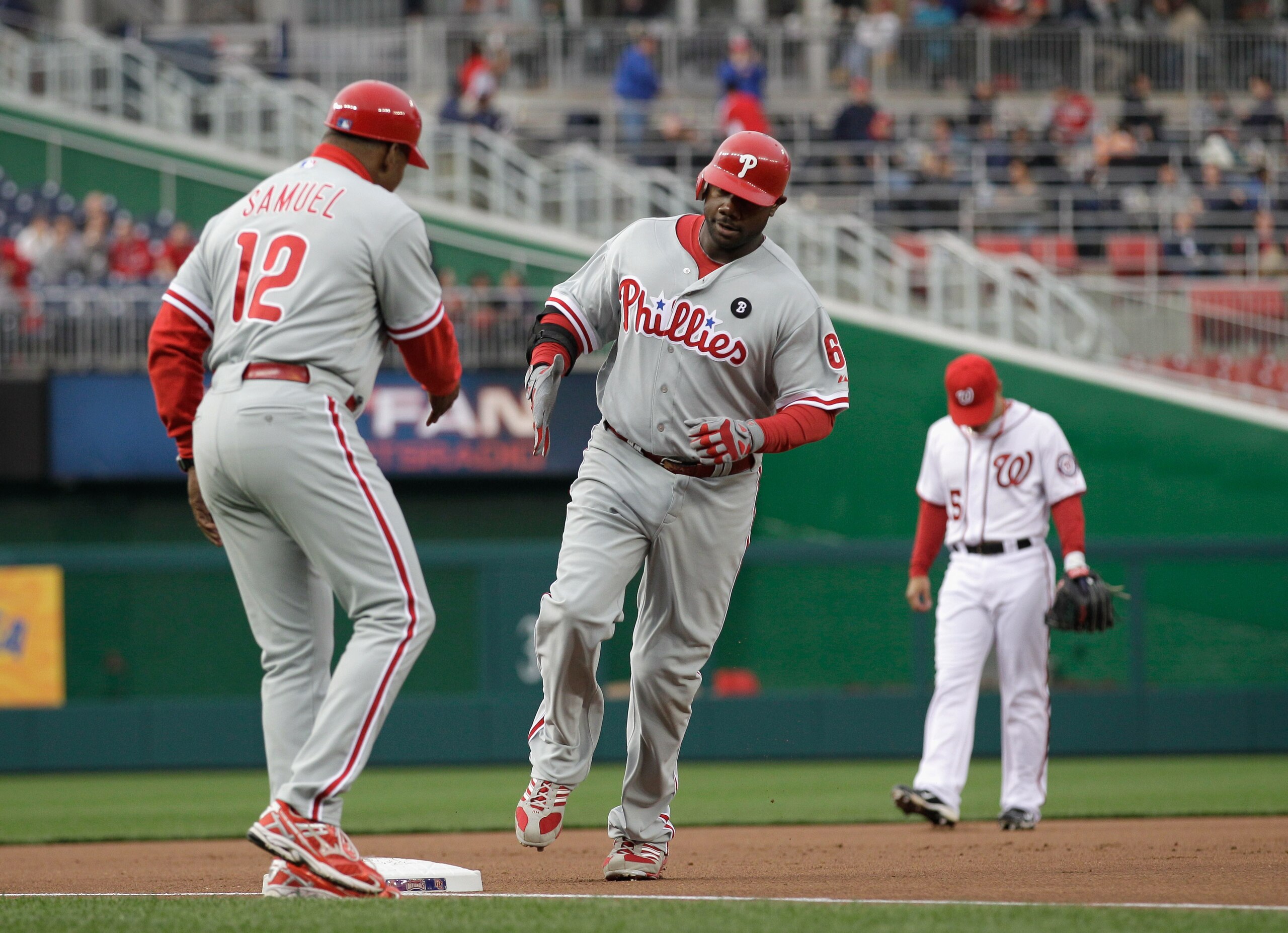 WASHINGTON, DC - APRIL 12:  Third base caoch Juan Samuel #12 congratulates Ryan Howard #6 of the Philadelphia Phillies after hitting a solo home run during the second inning against the Washington Nationals at Nationals Park on April 12, 2011 in Washingto