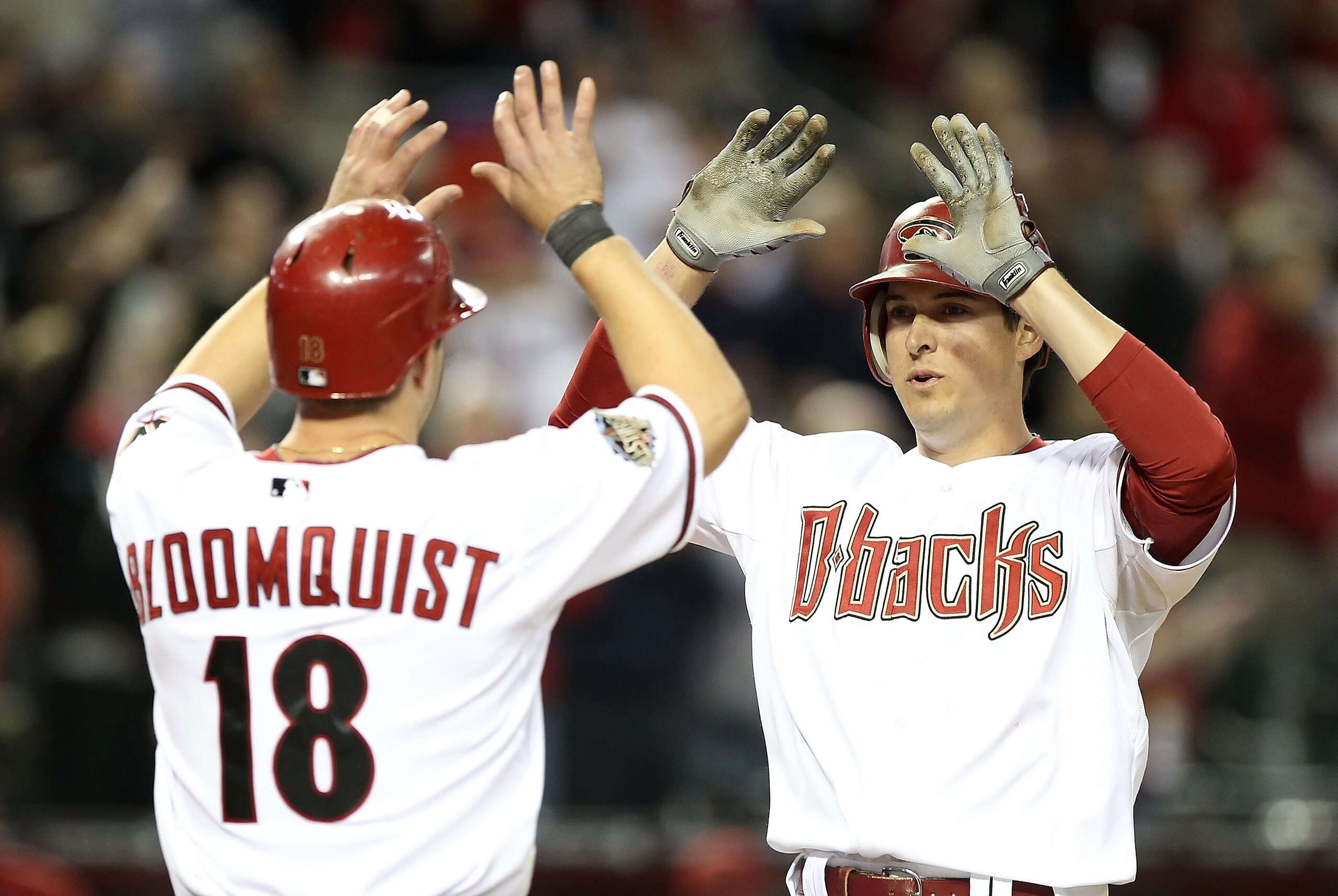 PHOENIX, AZ - APRIL 08:  Kelly Johnson #2 of the Arizona Diamondbacks high fives teammate Willie Bloomquist #18 after Johnson hit a 3 run home run against the Cincinnati Reds during the eighth inning of the Major League Baseball home opening game at Chase