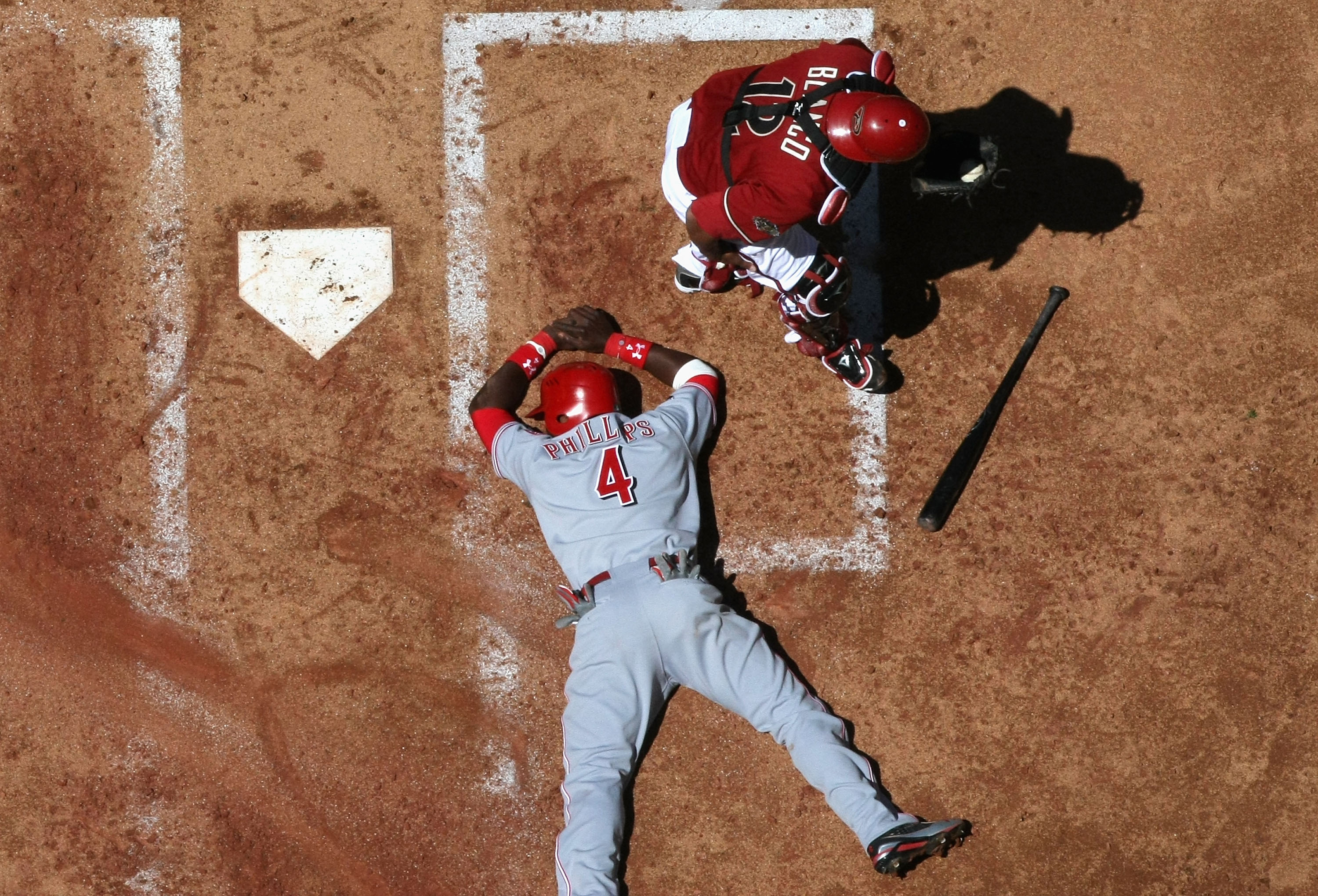 PHOENIX, AZ - APRIL 10:  Brandon Phillips #4 of the Cincinnati Reds is tagged out at home plate by catcher Henry Blanco #12 of the Arizona Diamondbacks as he attempts to score during the second inning of the Major League Baseball game at Chase Field on Ap
