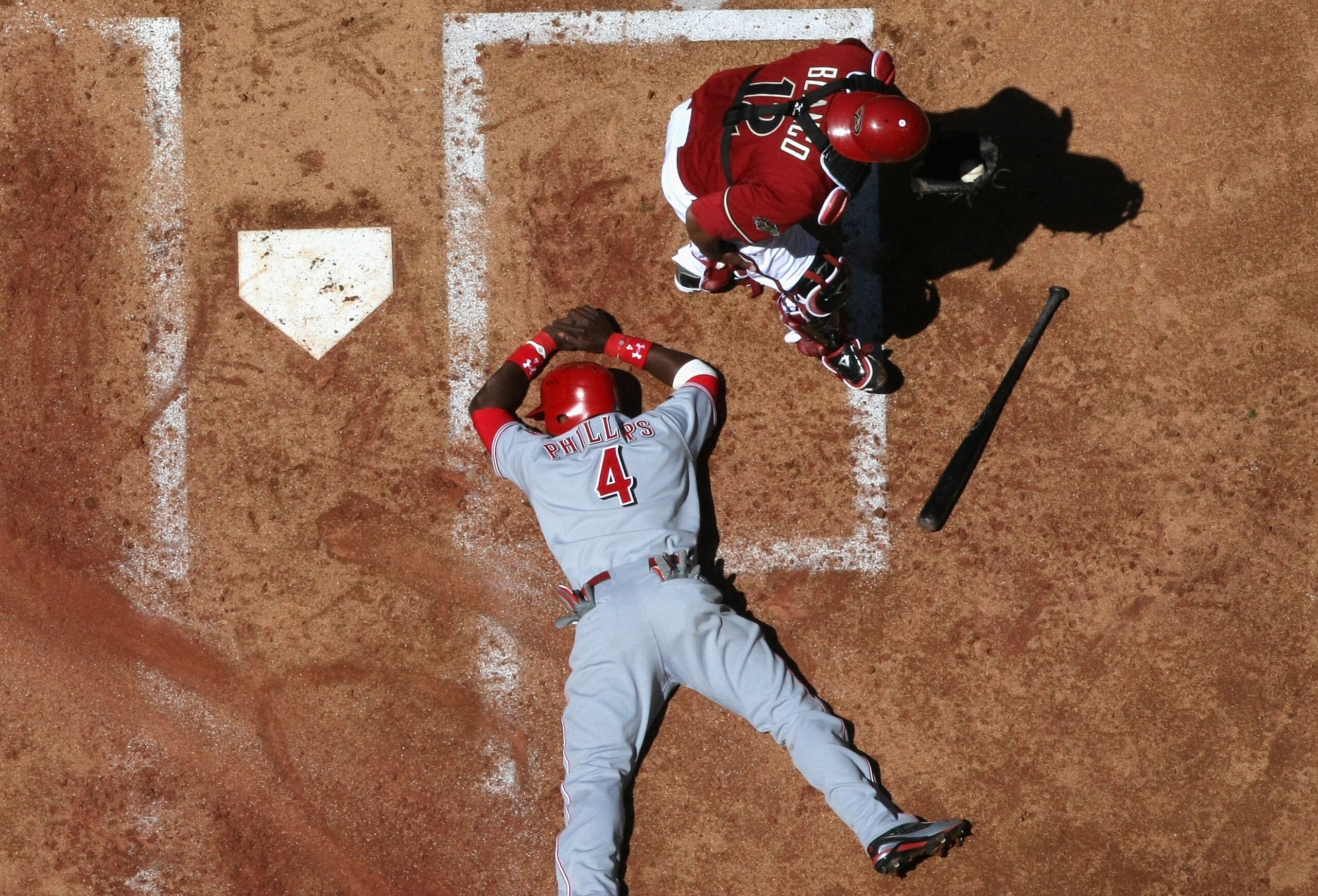 PHOENIX, AZ - APRIL 10:  Brandon Phillips #4 of the Cincinnati Reds is tagged out at home plate by catcher Henry Blanco #12 of the Arizona Diamondbacks as he attempts to score during the second inning of the Major League Baseball game at Chase Field on Ap