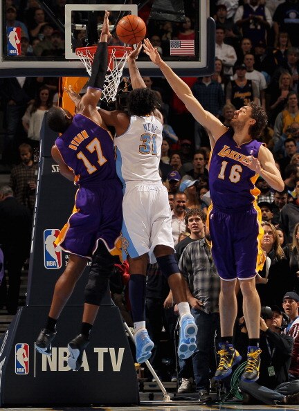 DENVER, CO - JANUARY 21:  Nene #31 of the Denver Nuggets puts up a shot between Andrew Bynum #17 and Pau Gasol #16 of the Los Angeles Lakers at the Pepsi Center on January 21, 2011 in Denver, Colorado. NOTE TO USER: User expressly acknowledges and agrees