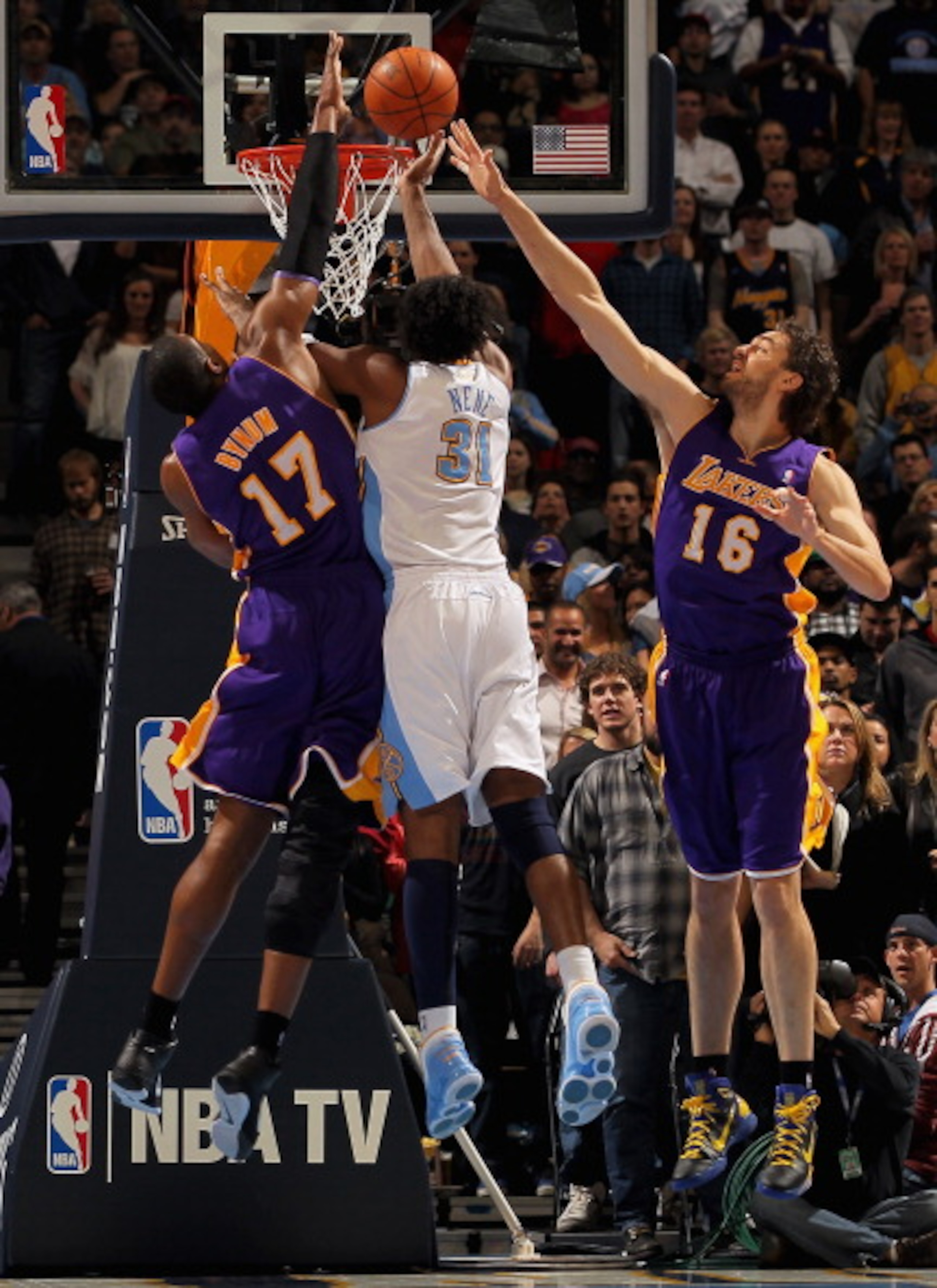 DENVER, CO - JANUARY 21:  Nene #31 of the Denver Nuggets puts up a shot between Andrew Bynum #17 and Pau Gasol #16 of the Los Angeles Lakers at the Pepsi Center on January 21, 2011 in Denver, Colorado. NOTE TO USER: User expressly acknowledges and agrees