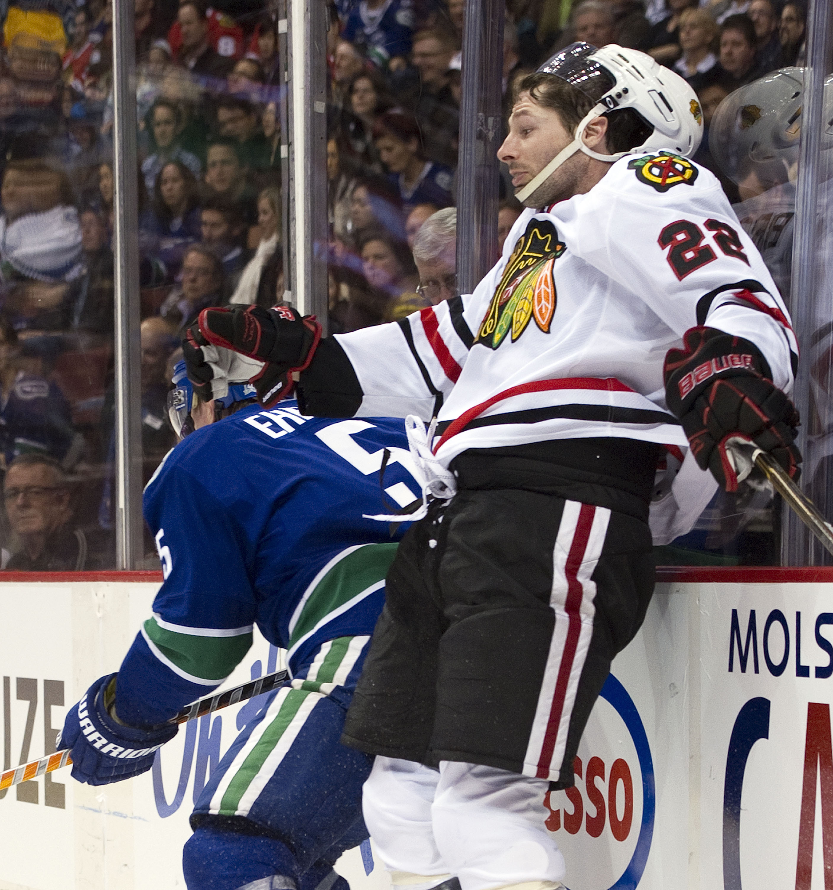 VANCOUVER, CANADA - FEBRUARY 4: Troy Brouwer #22 of the Chicago Blackhawks reacts after slamming into the end boards while trying to hit Christian Ehrhoff #5 of the Vancouver Canucks during the first period in NHL action on February 04, 2011 at Rogers Are