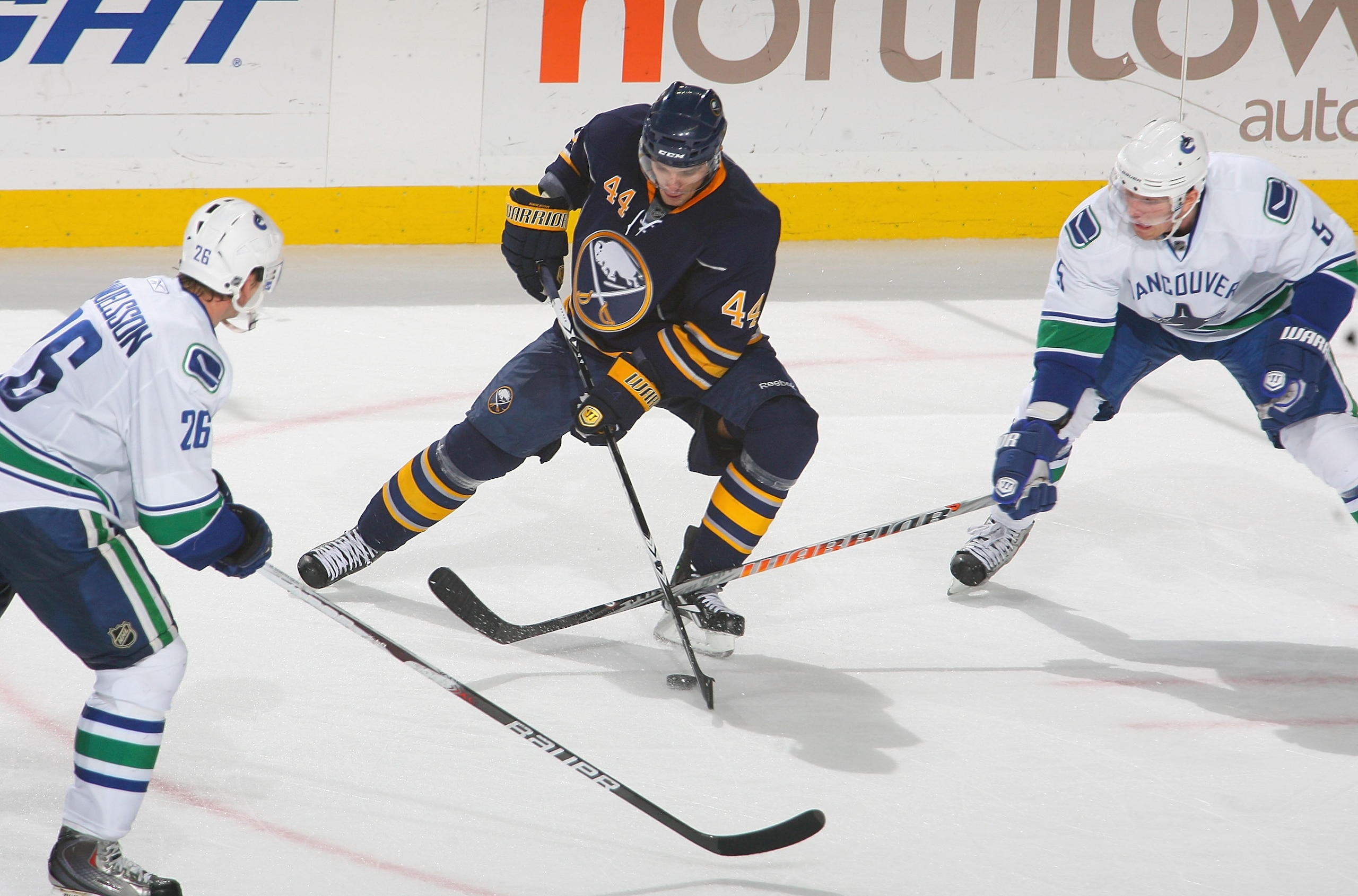BUFFALO, NY - NOVEMBER 15:  Andrej Sekera #44 of the Buffalo Sabres skates against Mikael Samuelsson #26 and Christian Ehrhoff #5  of the Vancouver Canucks at HSBC Arena on November 15, 2010 in Buffalo, New York. Buffalo won 4-3 in overtime.  (Photo by Ri