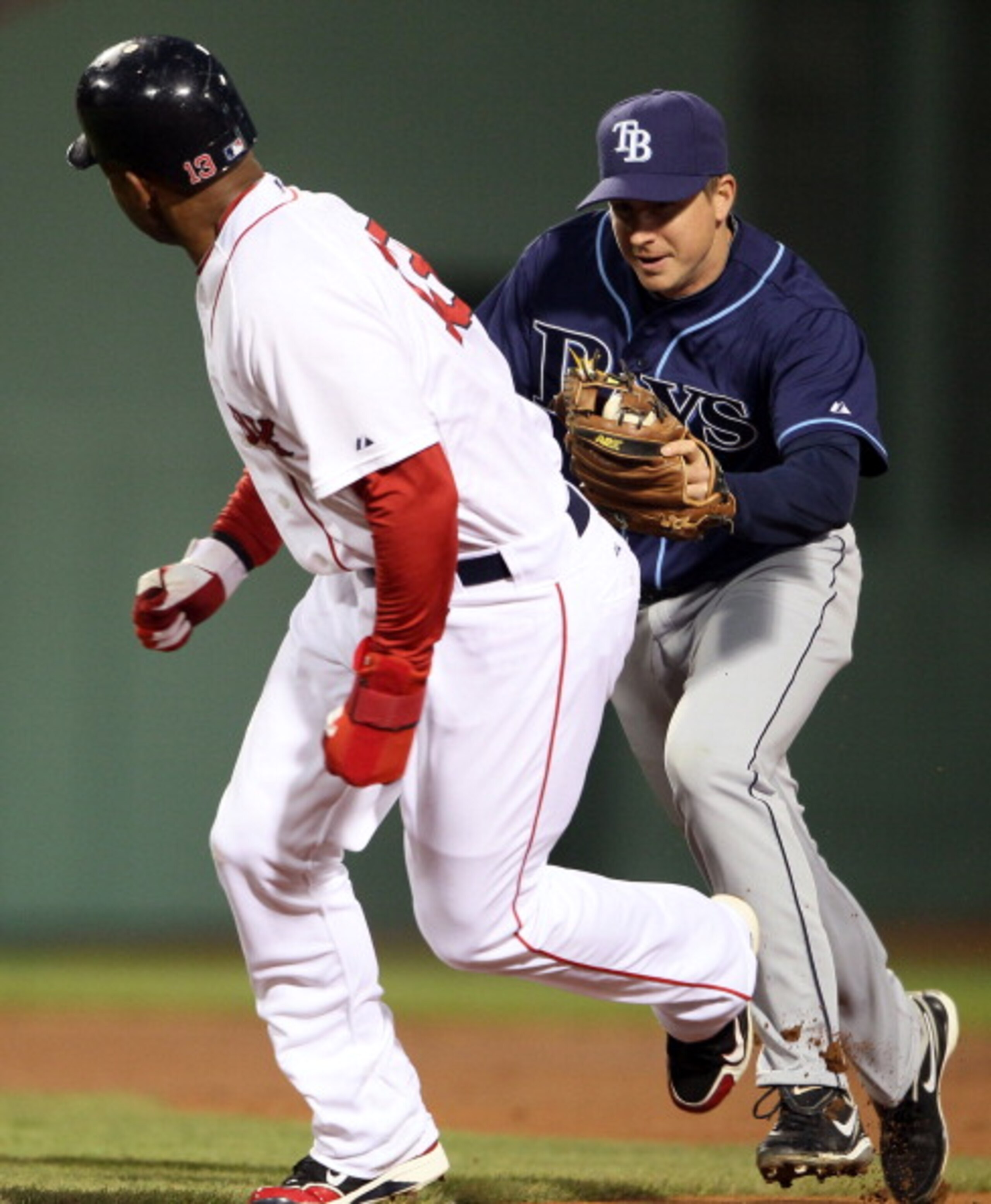 BOSTON, MA - APRIL 12:  Carl Crawford #13 of the Boston Red Sox is tagged by Elliot Johnson #9 of the Tampa Bay Rays on April 12, 2011 at Fenway Park in Boston, Massachusetts.  (Photo by Elsa/Getty Images)