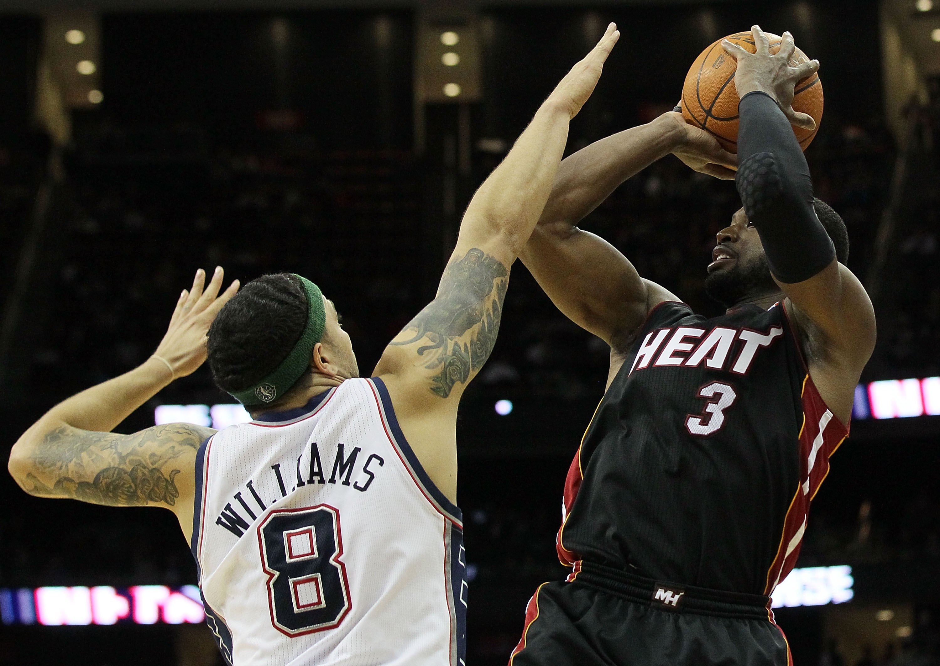 NEWARK, NJ - APRIL 03:  Dwyane Wade #3 of the Miami Heat shoots against Deron Williams #8 of the New Jersey Nets at the Prudential Center on April 3, 2011 in Newark, New Jersey.The Heat defeated the Nets 108-94.NOTE TO USER: User expressly acknowledges an