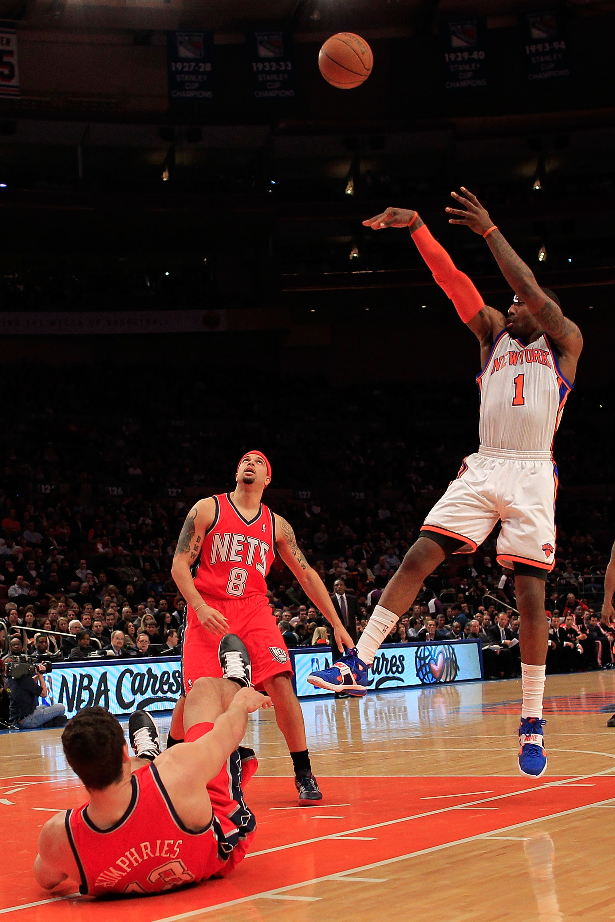 NEW YORK, NY - MARCH 30:  Amar'e Stoudemire #1 of the New York Knicks shoots over Deron Williams #8 and Kris Humphries #43 of the New Jersey Nets at Madison Square Garden on March 30, 2011 in New York City. NOTE TO USER: User expressly acknowledges and ag