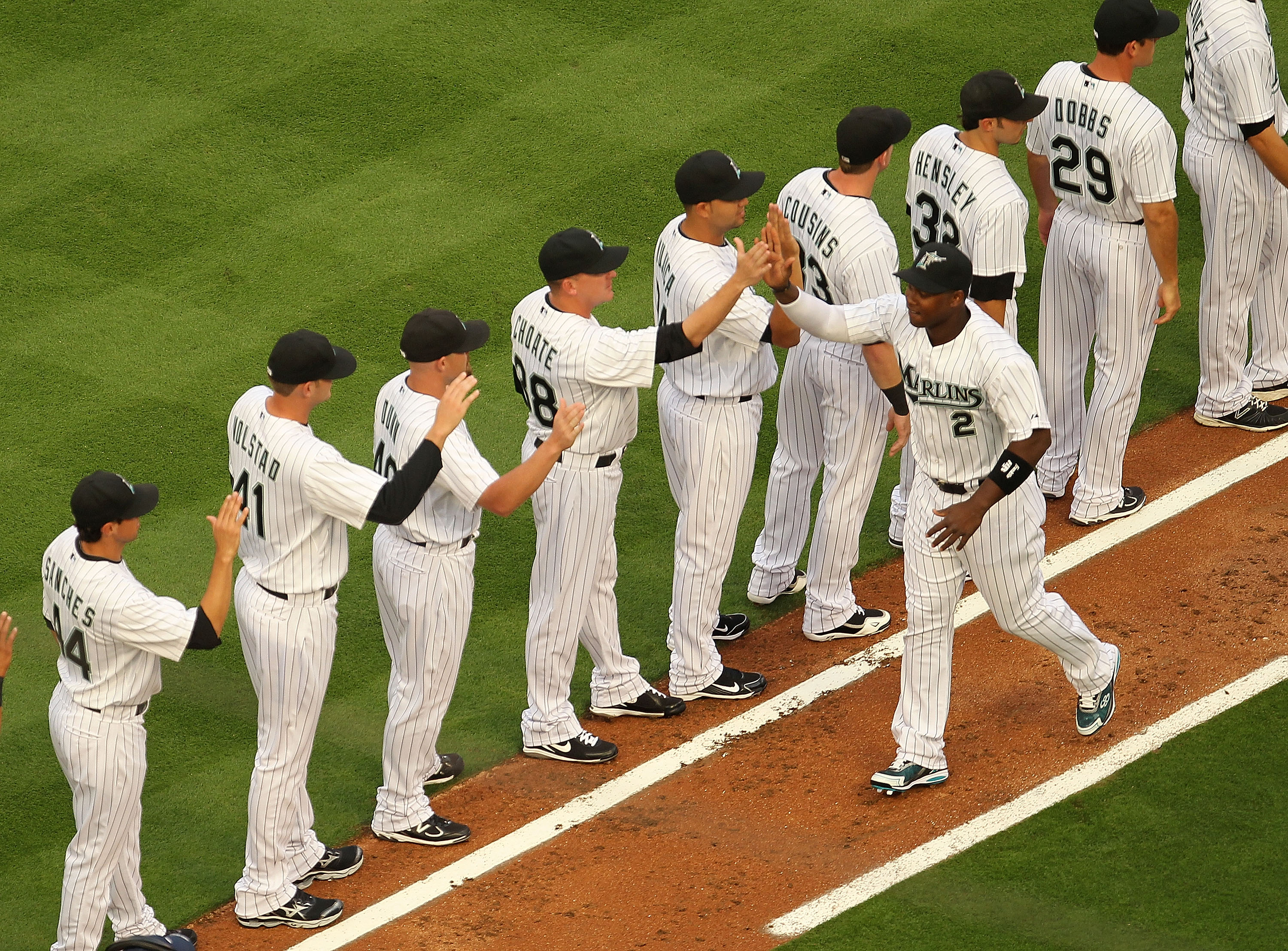 MIAMI GARDENS, FL - APRIL 01:  Hanley Ramirez #2 of the Florida Marlins is greeted by teammates during opening day against the New York Mets at Sun Life Stadium on April 1, 2011 in Miami Gardens, Florida.  (Photo by Mike Ehrmann/Getty Images)
