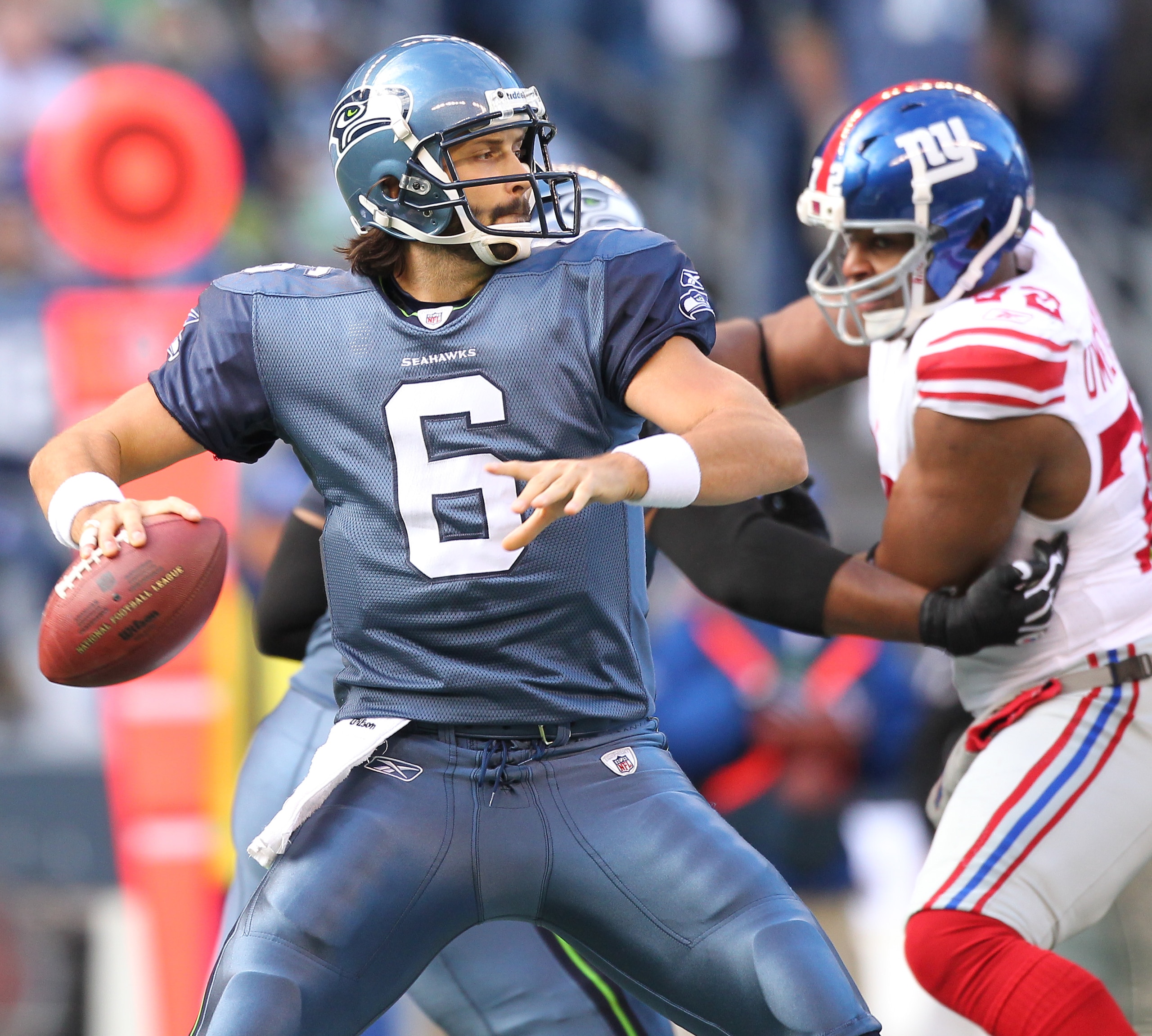 SEATTLE - NOVEMBER 07:  Quarterback Charlie Whitehurst #6 of the Seattle Seahawks passes against  Osi Umenyiora #72 of the New York Giants at Qwest Field on November 7, 2010 in Seattle, Washington. The Giants defeated the Seahawks 41-7. (Photo by Otto Gre