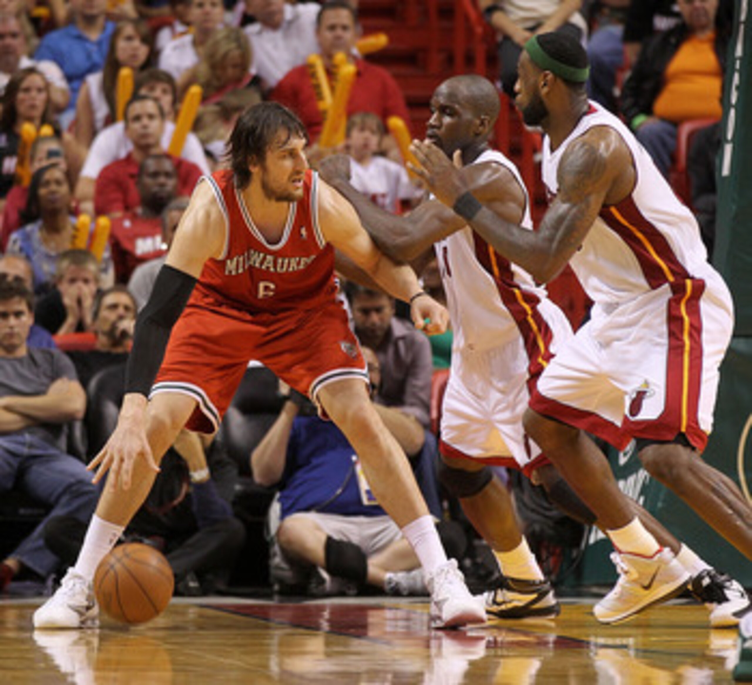 MIAMI, FL - APRIL 06:  Andrew Bogut #6 of the Milwaukee Bucks posts up  Joel Anthony #50 and LeBron James #6 of the Miami Heat during a game at American Airlines Arena on April 6, 2011 in Miami, Florida. NOTE TO USER: User expressly acknowledges and agree