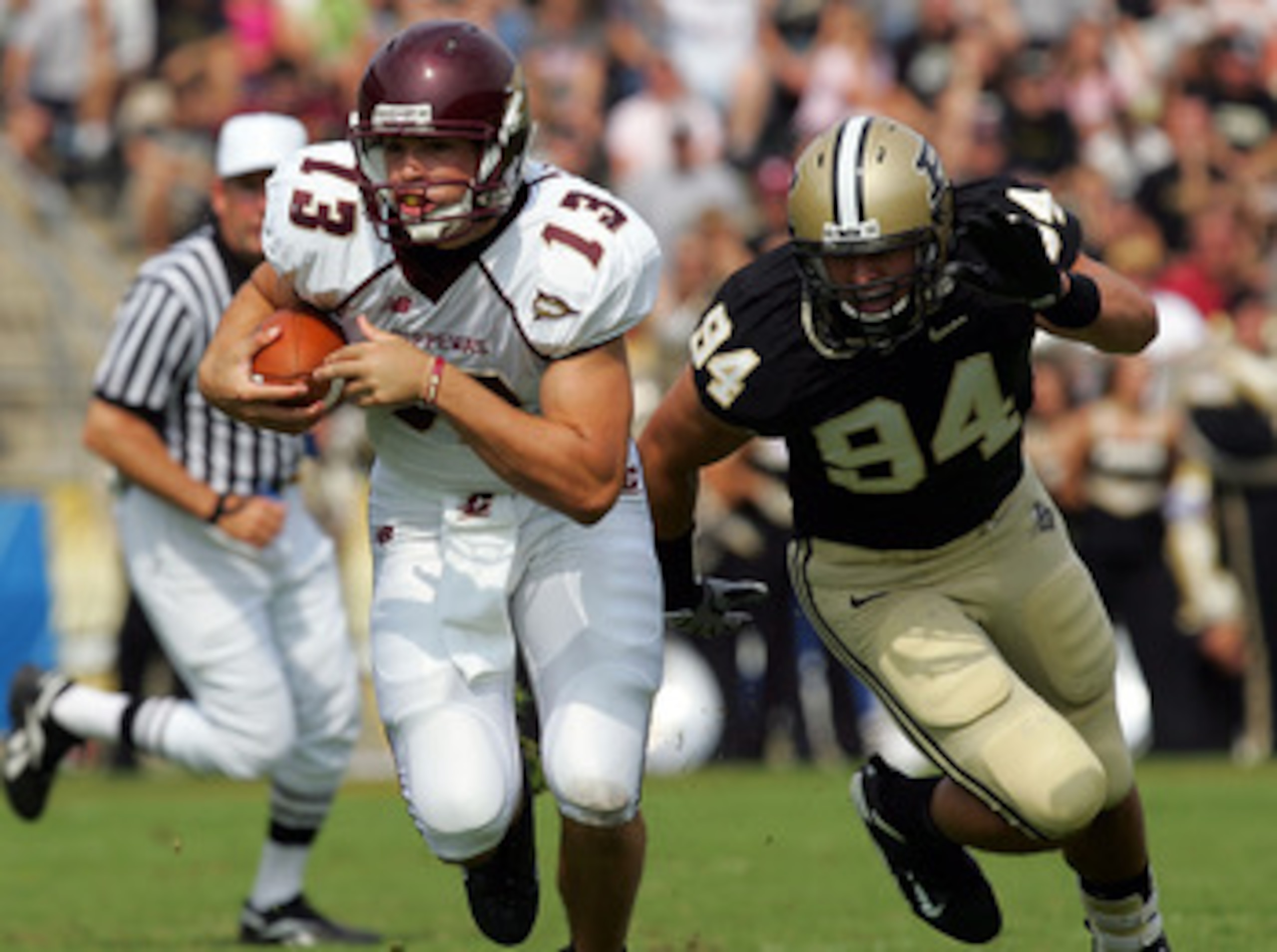WEST LAFAYETTE, IN - SEPTEMBER 20:  Quarterback Dan LeFevour #13 of the Central Michigan Chippewas runs the ball past Ryan Kerrigan #94 of the Purdue Boilermakers at Ross-Ade Stadium on September 20, 2008 in West Lafayette, Indiana.  (Photo by Ronald Mart
