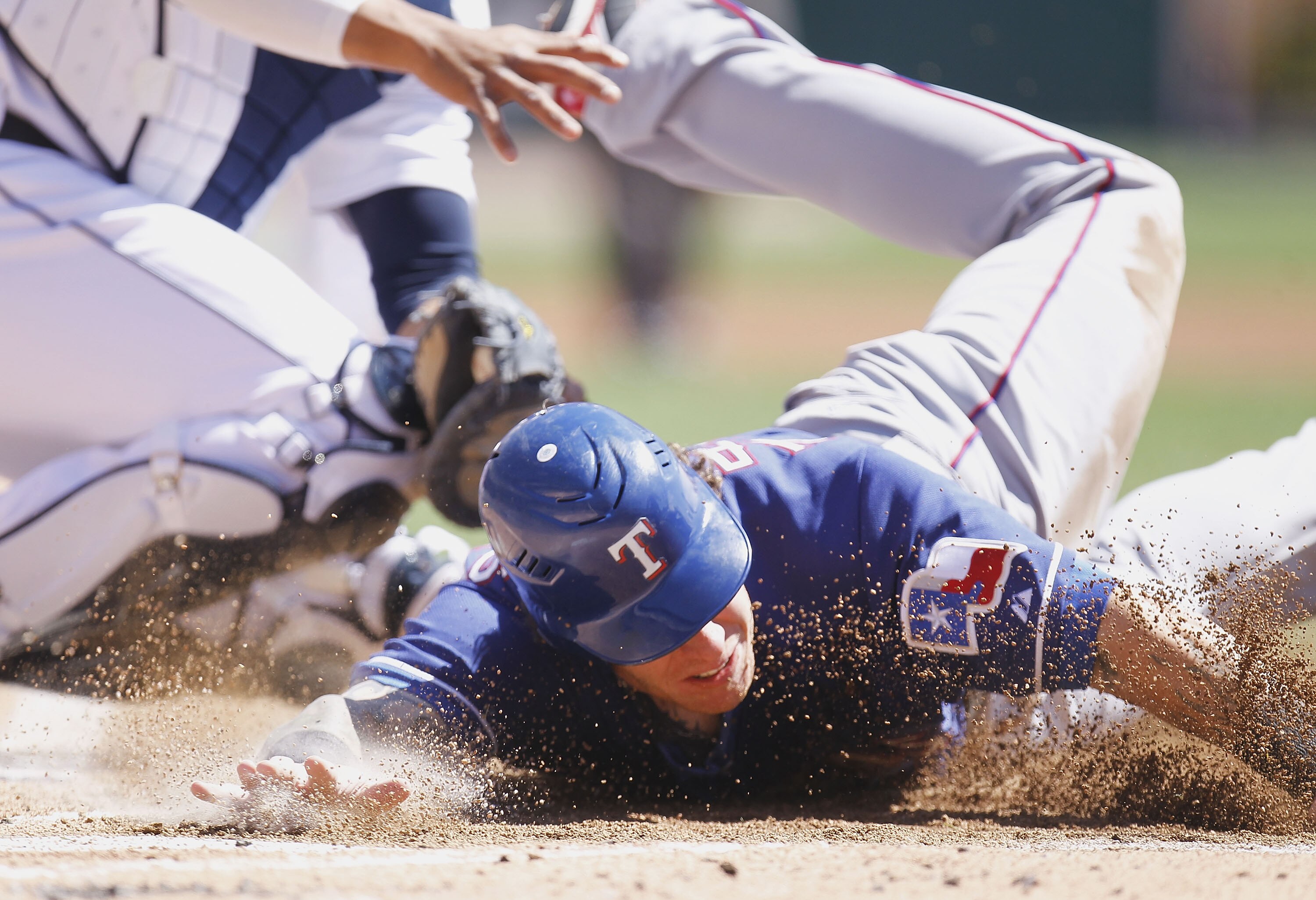 DETROIT, MI - APRIL 12:  Josh Hamilton #32 of the Texas Rangers slides into home plate during the third inning while playing the Detroit Tigers at Comerica Park on April 12, 2011 in Detroit, Michigan. Hamilton was out from a tag by Victor Martinez  (Photo
